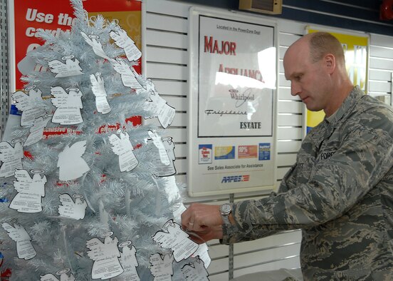 SHAW AIR FORCE BASE, S.C. -- Col. James Post, 20th Fighter Wing commander, selects the first angel from the Shaw angel tree Nov 19. The Shaw angel tree is a base-wide effort sponsored by the chapel to reach out and help those Airmen that have a difficult time during the Christmas holiday to provide gifts for their children.  (U.S. Air Force photo/Airman 1st Class William Coleman)
