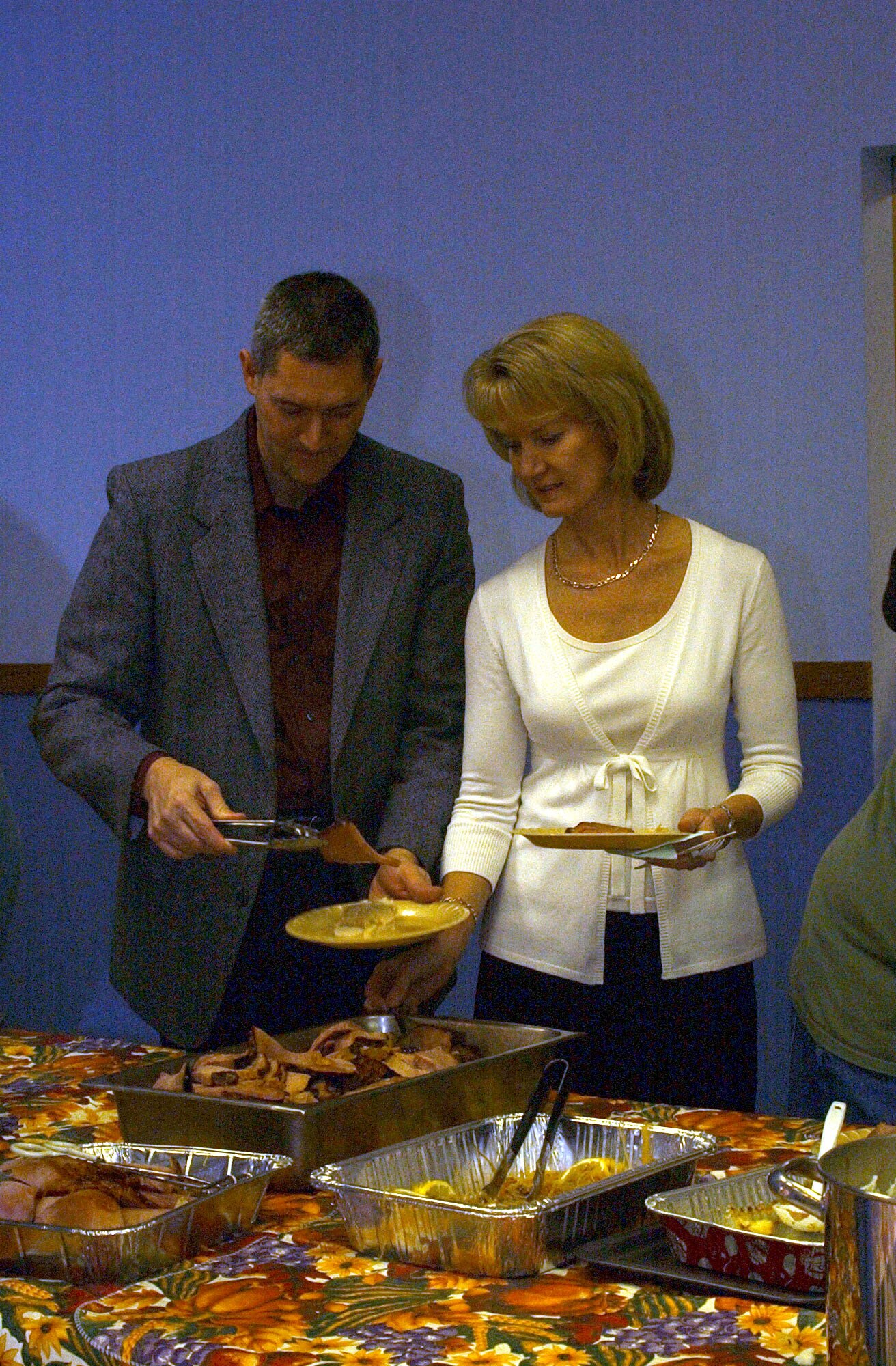 Col. Paul Gydesen, 341st Space Wing vice commander, and his wife, Suzanne, help themselves to some ham as they go throught the  buffet line Sunday at the annual community Thanksgiving dinner. The event is held annually and is sponsored by the Catholic and Protestant communities of Malmstrom. (U.S. Air Force photo/Valerie Mullett)