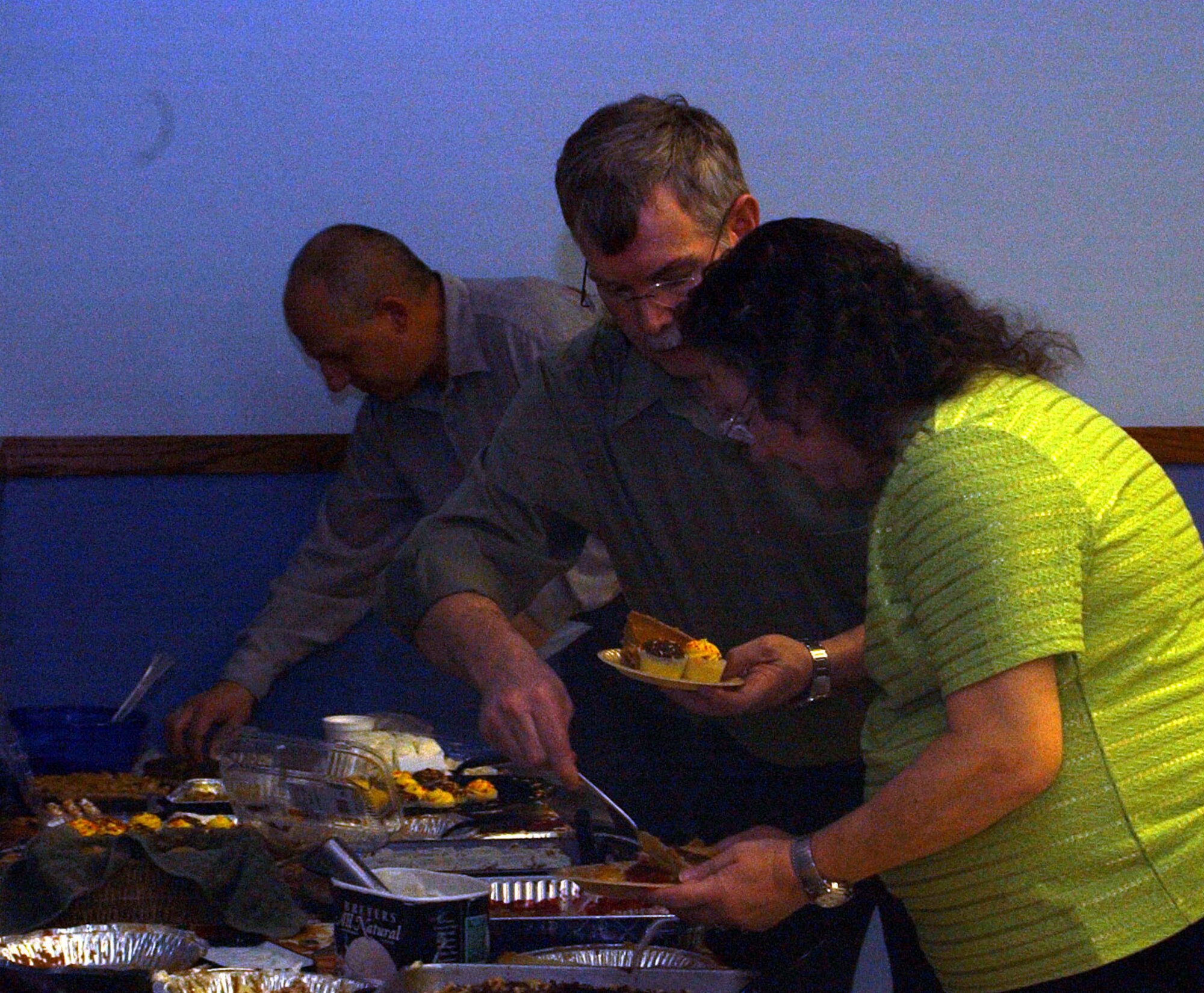 Fred Sadler places a piece of pumpkin pie on his wife, Belinda's, plate while Chaplain (Maj.) Keith Muschinske, gets a sweet treat for himself at the community Thanksgiving dinner at the Chapel Annex Sunday. The annual holiday event is sponsored by the Catholic and Protestant communities of Malmstrom. (U.S. Air Force photo/Valerie Mullett)
