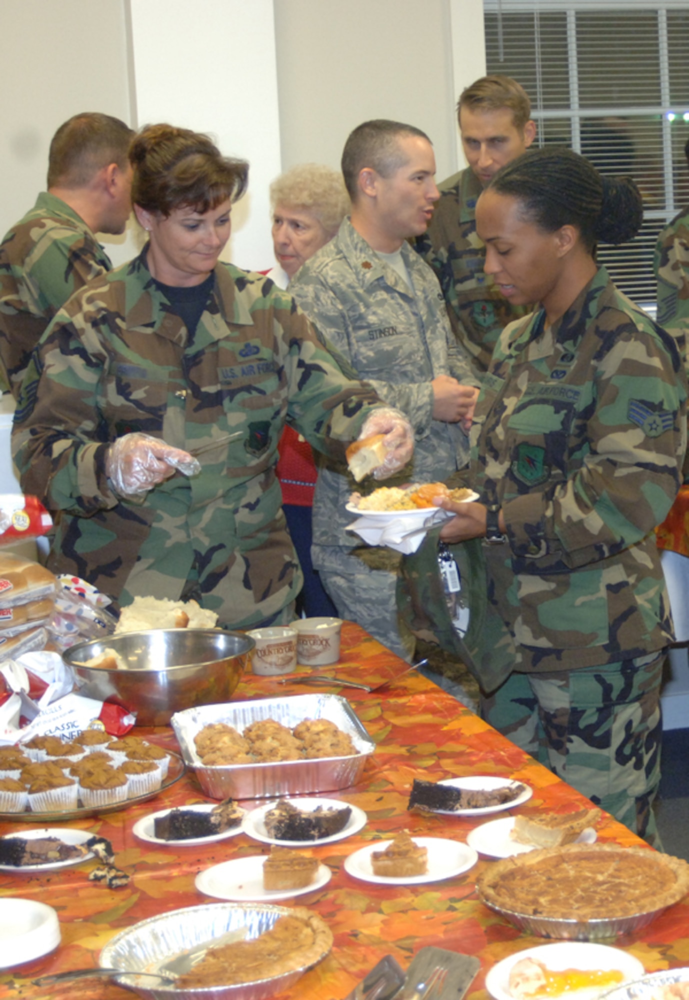 Senior Master Sgt. Judy Griffis, 14th Comptroller Squadron, serves food to Senior Airman Arlene Harris, 14th Civil Engineer Squadron, during the Dormsgiving Thursday. Dorm residents were treated to a Thanksgiving dinner at the Chapel. (U.S. Air Force photo by Airman 1st Class Danielle Powell)