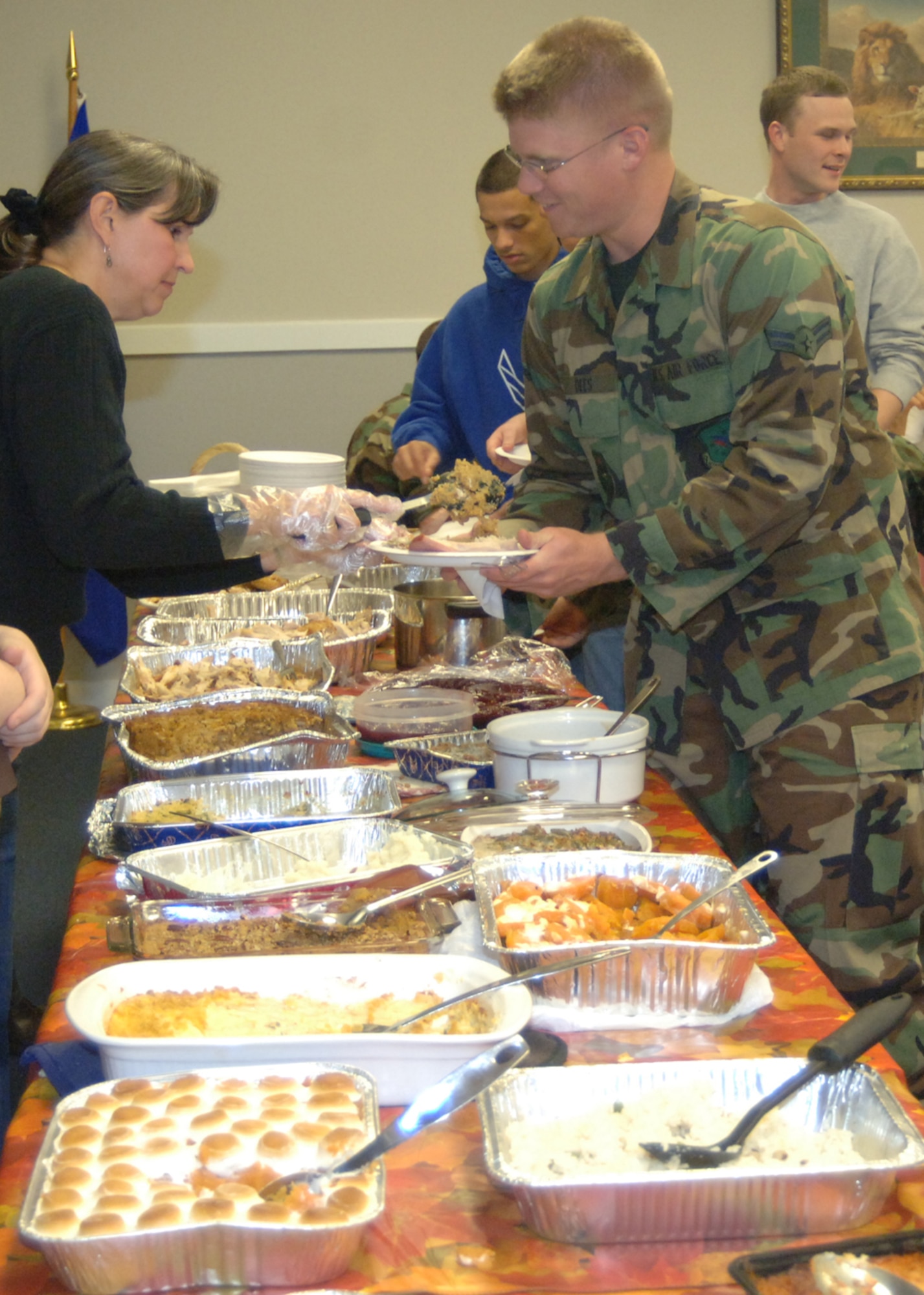 The wife of the 14th Flying Training Wing commander, 
Louisa Gerber, serves dinner to Airman 1st Class Ryan Dees, 14th Operations Support Squadron, during the Dormsgiving Thursday. Dorm residents were treated to a Thanksgiving dinner at the Chapel. (U.S. Air Force photo by Airman 1st Class Danielle Powell)