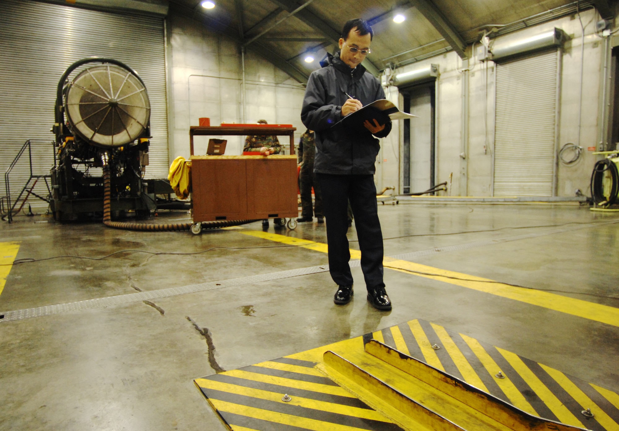 MOUNTAIN HOME AIR FORCE BASE, Idaho -- Yap, Kwek Leong, a representative from the Republic of Singapore Air Force, jots down the dimensions of a device used to secure an F-15 in place while the engines are tested at the "hush house" here, Nov 14. The RSAF has toured the base's facilities on multiple occasions, preparing to bring close to 500 pilots, maintainers, and their families by April 2009. The RSAF will also bring ten F-15SG's, a reproduction of the F-15E Strike Eagle, to train and fly with the pilots . (U.S. Air Force photo/ Airman 1st Class Ryan Crane)