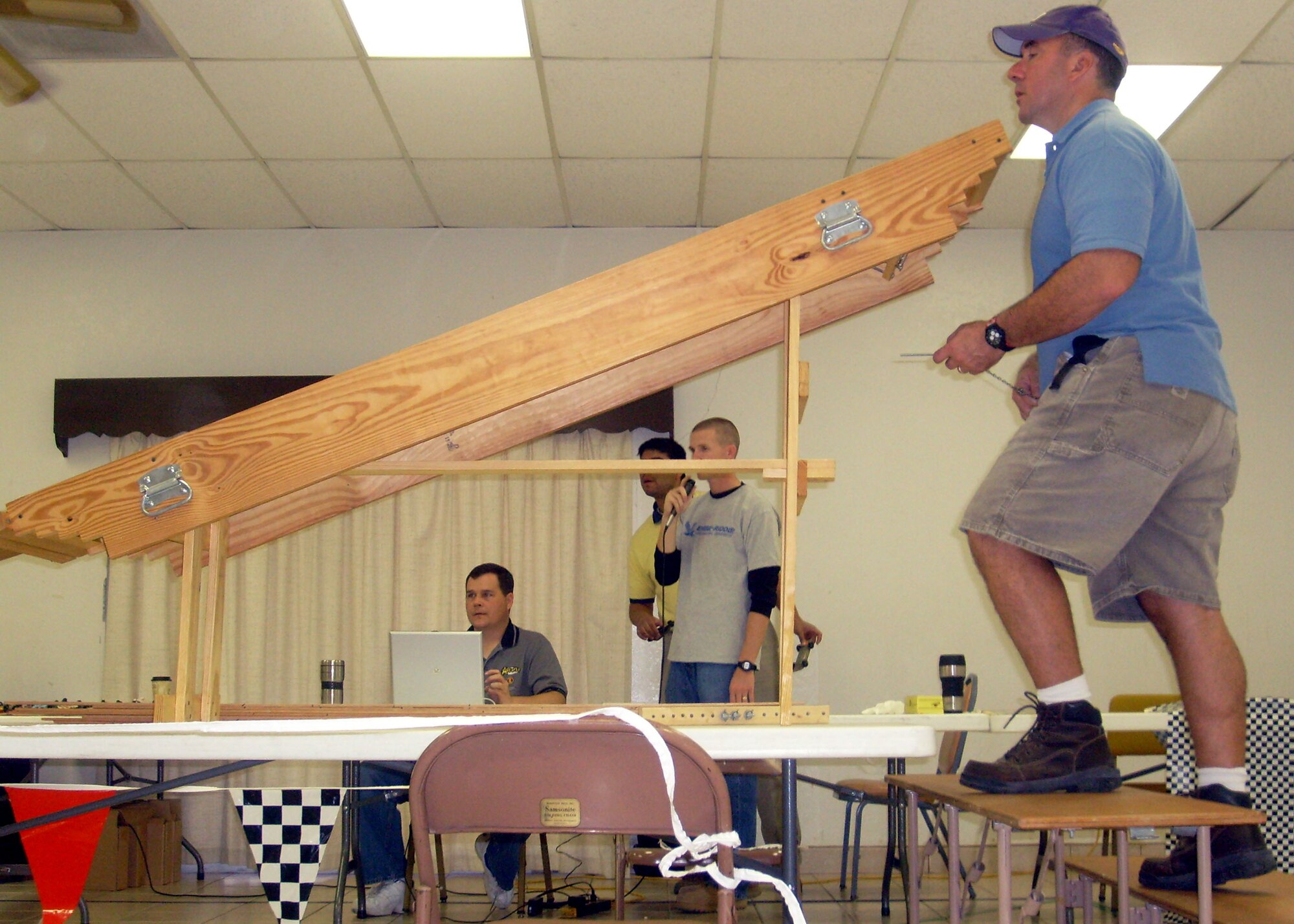 DEL RIO, Texas – Foreground, Frank Ochello, a former B-52 pilot and instructor and now a 47th Operations Group flight simulator instructor with contractor Lear/Sigler, Inc., lets lose a group of racecars to speed toward a photo finish. Background left to right, Master Sgt. Dave Drotts, 47th Force Support Squadron; Robert Estrada, 47th Civil Engineer Squadron; and 2nd Lt. Ryan Vanbuskirk, 47th Operations Support Squadron call the heat’s finish in Del Rio's 2007 AWANA Grand Prix. (U.S. Air Force photo/Capt. Ken Hall)