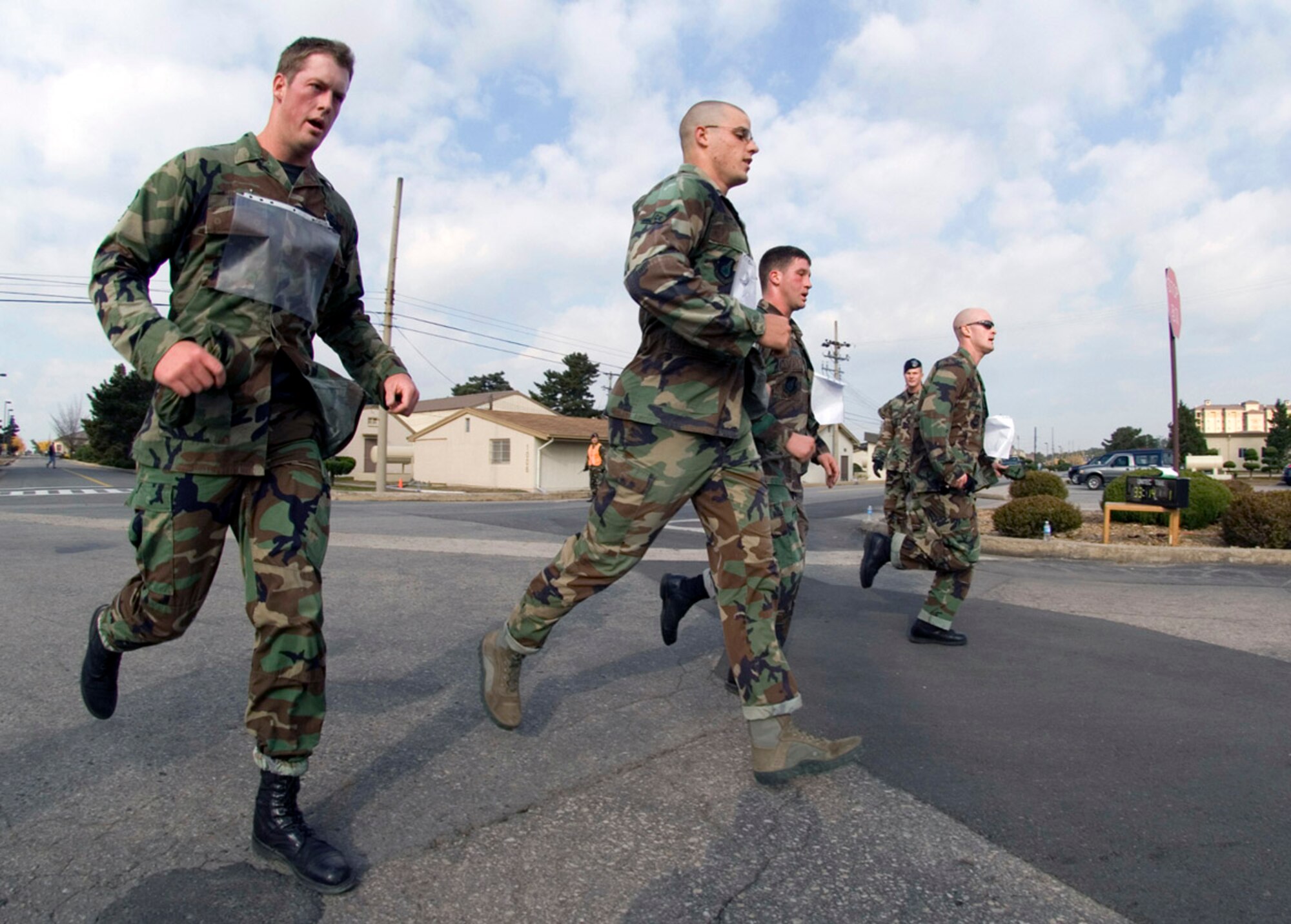 Members of the 8th Security Forces Squadron team, (from left) Senior Airman Brad Tubbs, Senior Airman Dustin Manning, Airman James Butler and 1st Lt. Brett Skates, cross the finish line of the 1st Veterans Day Memorial Ruck/Run held Nov. 17 at Kunsan Air Base, Republic of Korea. Ten teams, each comprising four members, participatied in the 10K march carrying 40-pound ruck sacks followed by a 1.5 mile run. The 8th SF team finished in first place with an overall team time of 1:33:16. Teams from the Republic of Korea air force joined U.S. teams from Kunsan and Osan air bases for the competition in an effort to build teamwork and camaraderie. (U.S. Air Force Photo/Master Sgt. Jack Braden) 