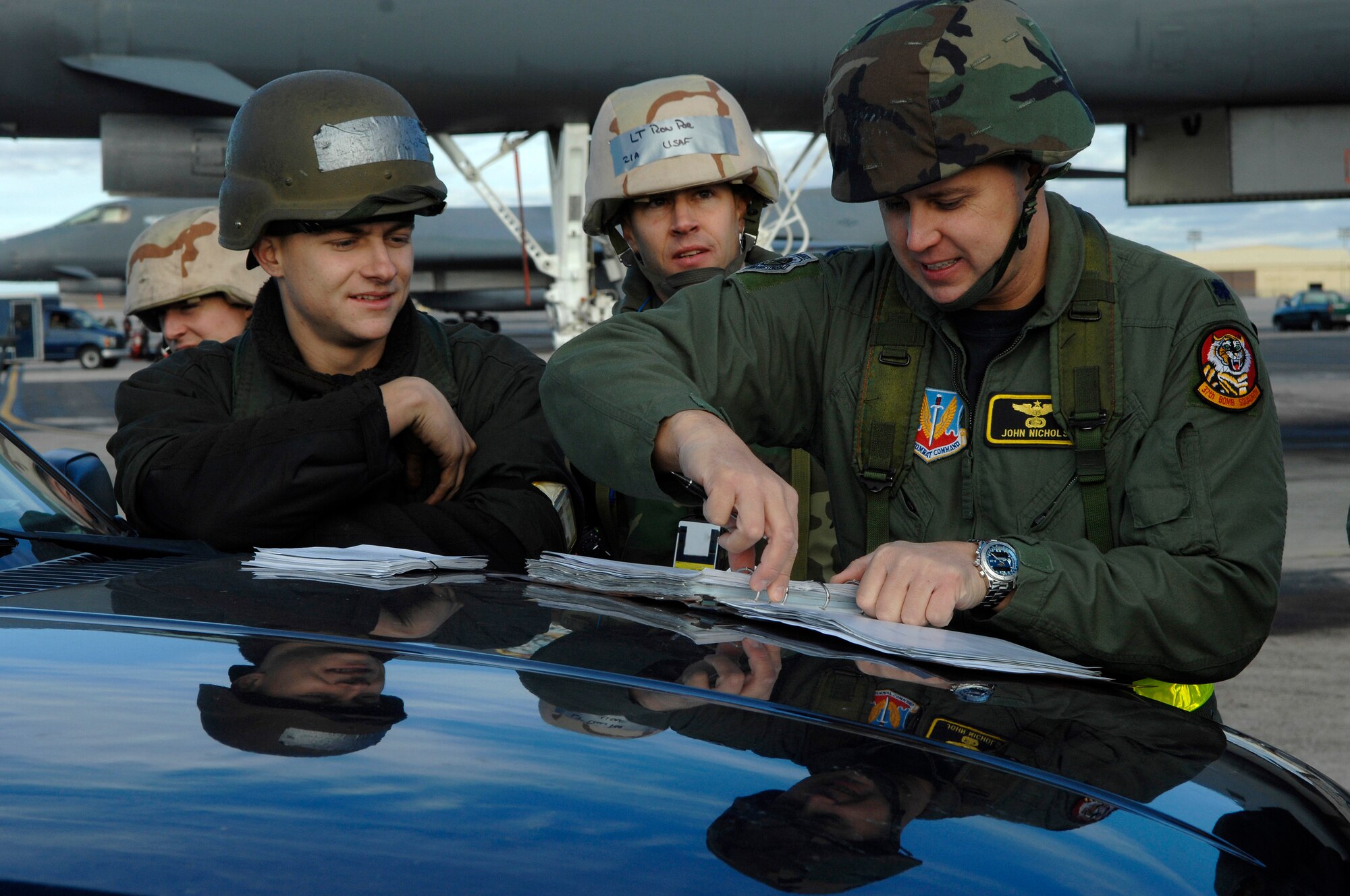 U.S. Air Force Airman 1st Class Edward Kovalcin (left), and 1st Lt. Wilburn Poe, both from the 28th Aircraft Maintenance Squadron, present Lt. Col. John Nichols, from the 37th Bomb Squadron, the maintenance paperwork for a B-1B Lancer prior to having it inspected during Operational Readiness Inspection (ORI) Coronet White 07-ACC-12 at Ellsworth Air Force Base, S.D., Nov. 17, 2007.  An Air Combat Command inspection team will use this ORI to evaluate Ellsworth's ability to effectively and rapidly deploy.  (U.S. Air Force photo/Staff Sgt. Michael B. Keller)