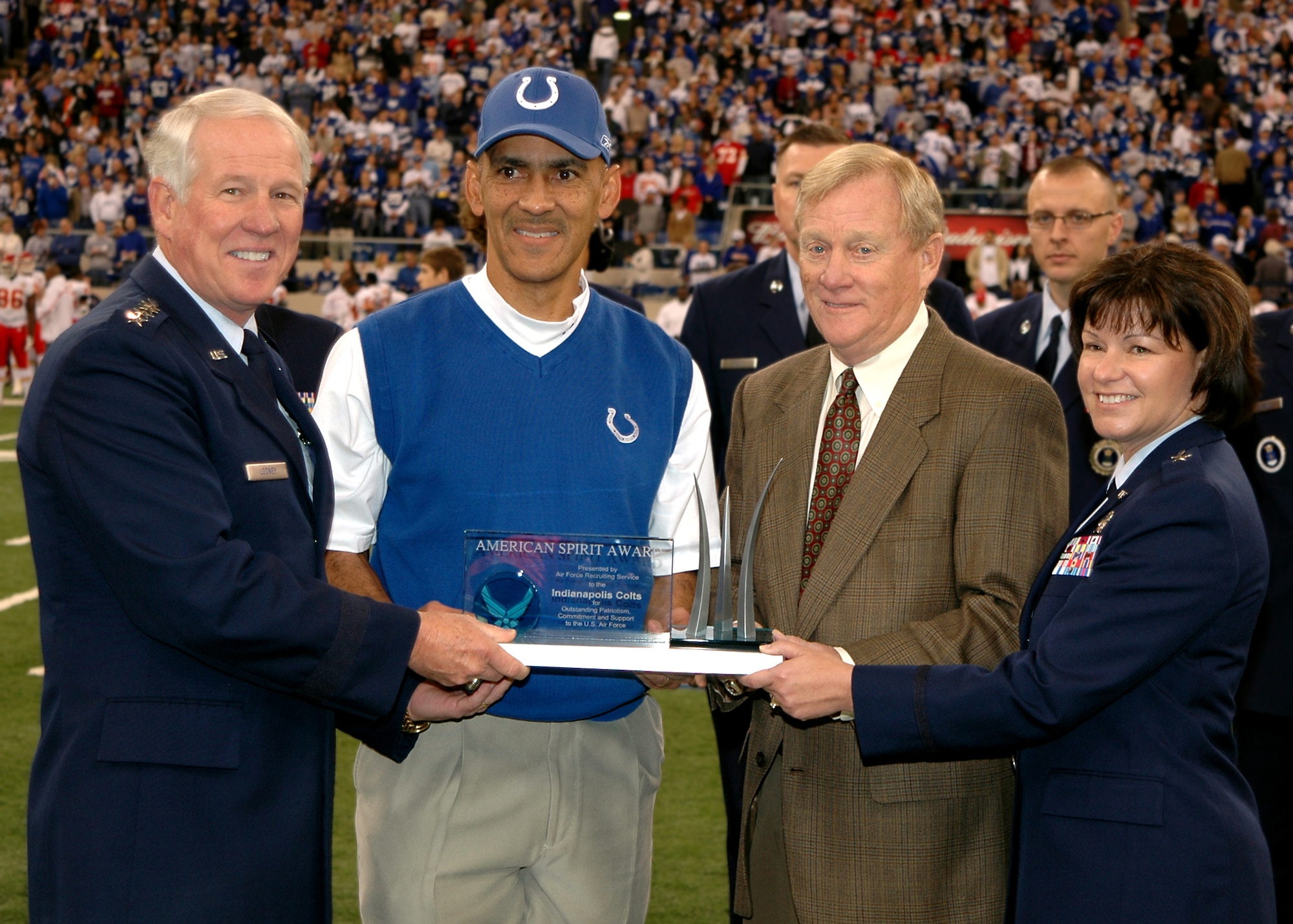 General William R. Looney III, Air Education and Training Command commander, and Air Force Recruiting Service commander, Brig. Gen. Suzanne Vautrinot, present Indianapolis Colts team president Bill Polian (middle right) and head coach Tony Dungy with the prestigious American Spirit Award at midfield prior to kickoff of the Colts vs Kansas City Chiefs National Football League game at the RCA Dome, Nov. 18 in Indianapolis. (U.S. Air Force photo by Senior Airman Carl Berry)