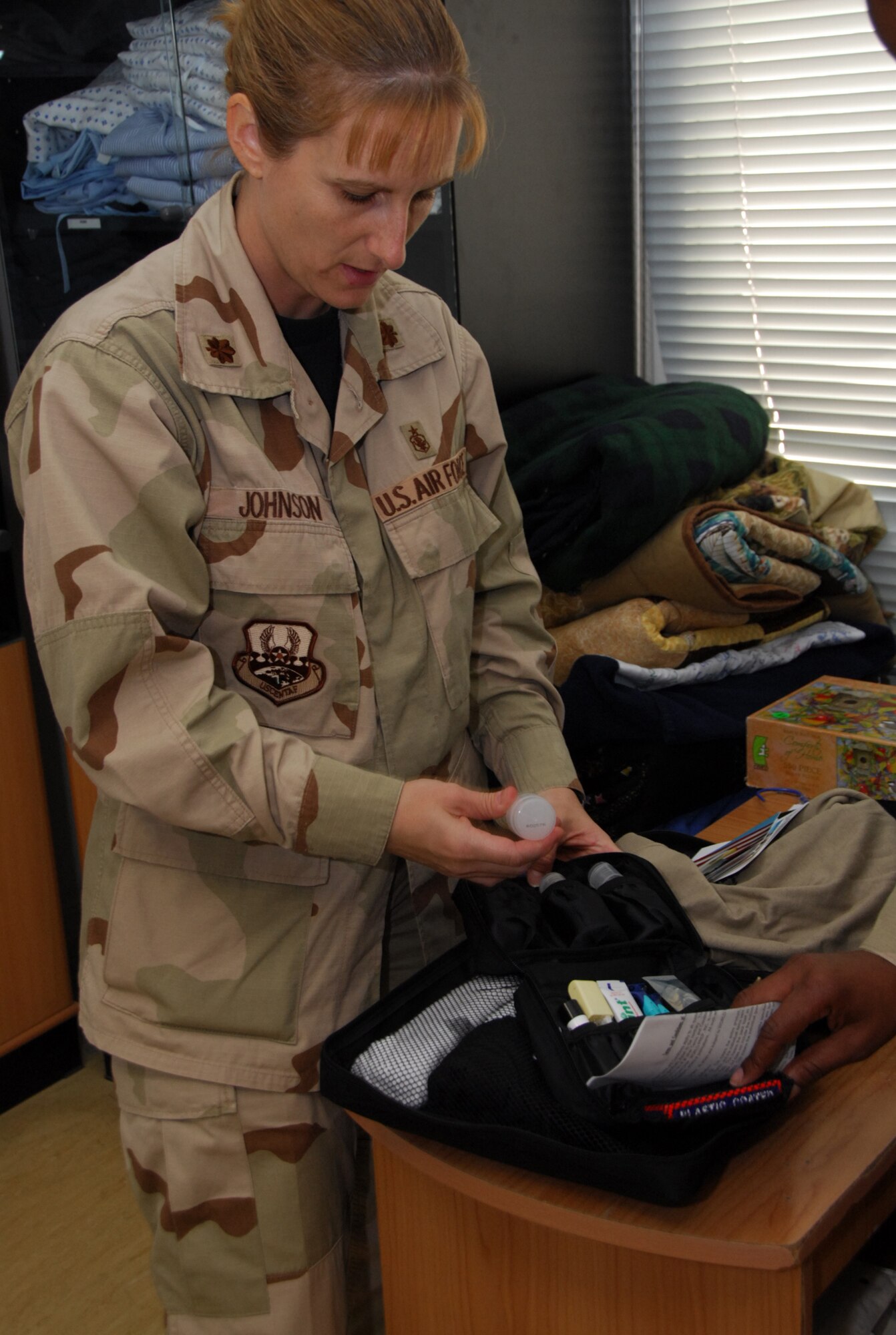 SOUTHWEST ASIA - Maj. Nancy Johnson, 379th Expeditionary Medical Group, sorts through  a Transitional Care Pack, desinged to contain essential care and comfort items for those in the Wounded Warrior Program. (U.S. Air Force photo/Staff Sgt. Doug Olsen)