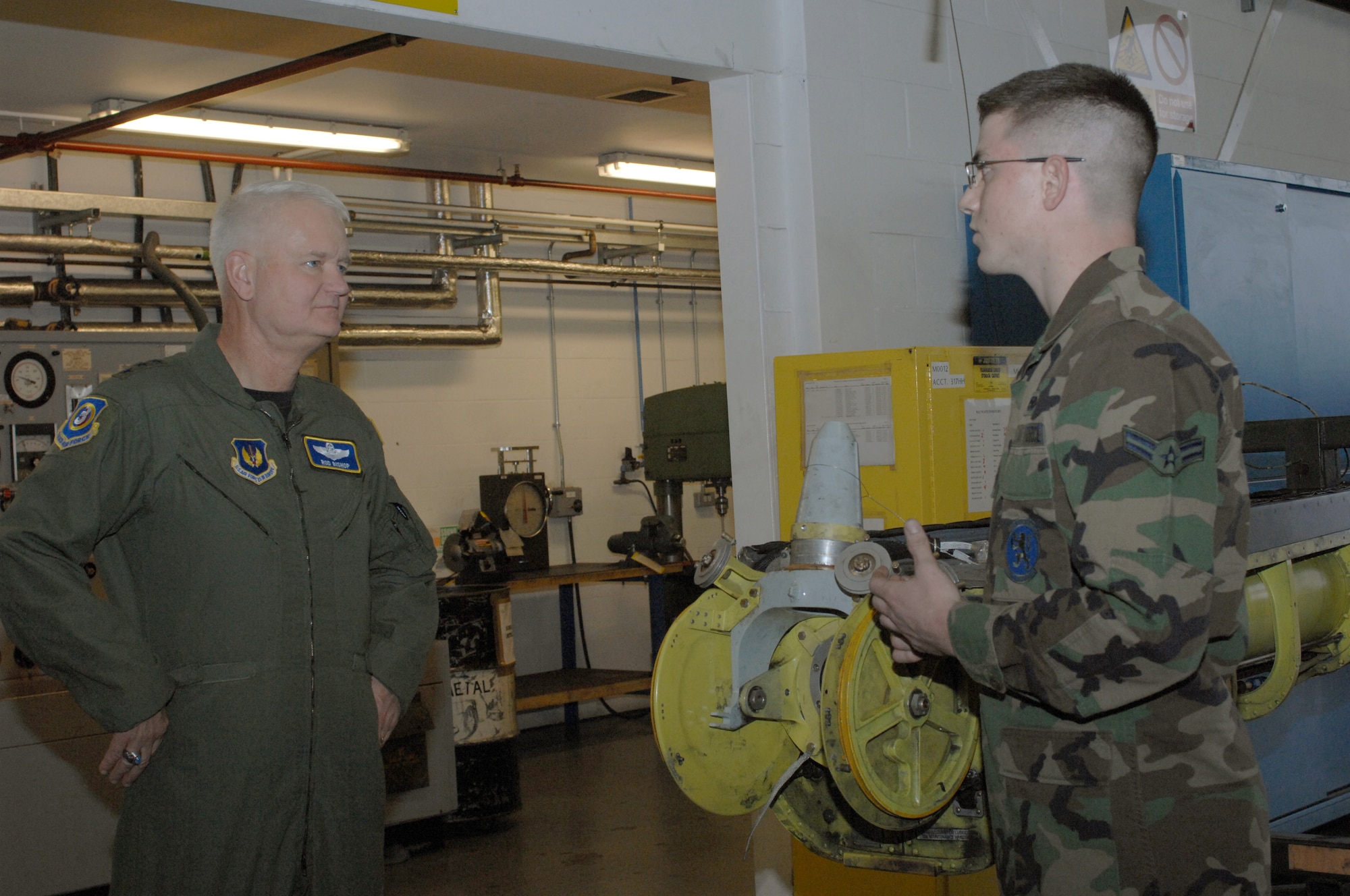 Airman 1st Class Ross Drown, 100th Maintenance Squadron (right), explains how the hydraulics flight helps keep RAF Mildenhall's fleet of KC-135 mission capable to Lt. Gen. Rod Bishop, 3rd Air Force commander. The general toured units at RAF Mildenhall during a visit Nov. 7. (U.S. Air Force photo by Airman 1st Class Brad Smith) 