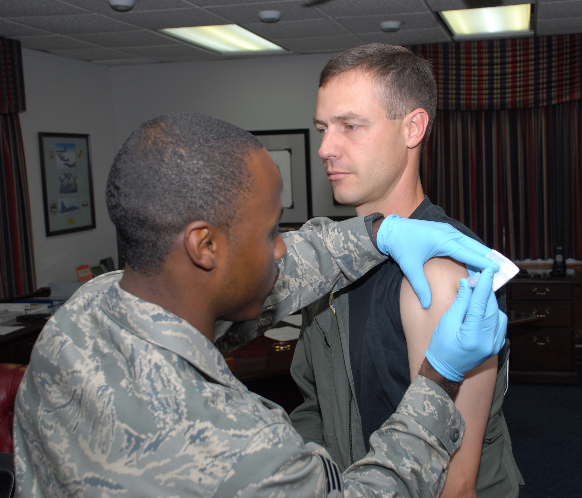 Senior Airman Dari Moore, 436th Aeromedical Dental Operations Squadron, administers the influenza vaccine to Col. Steven Harrison, 436th Airlift Wing commander, Nov. 1.  The vaccine is now available at the Immunization Clinic for  anyone eligible for care at the military treatment facility. (U.S. Air Force photo/Master Sgt. Steve Marciniak)