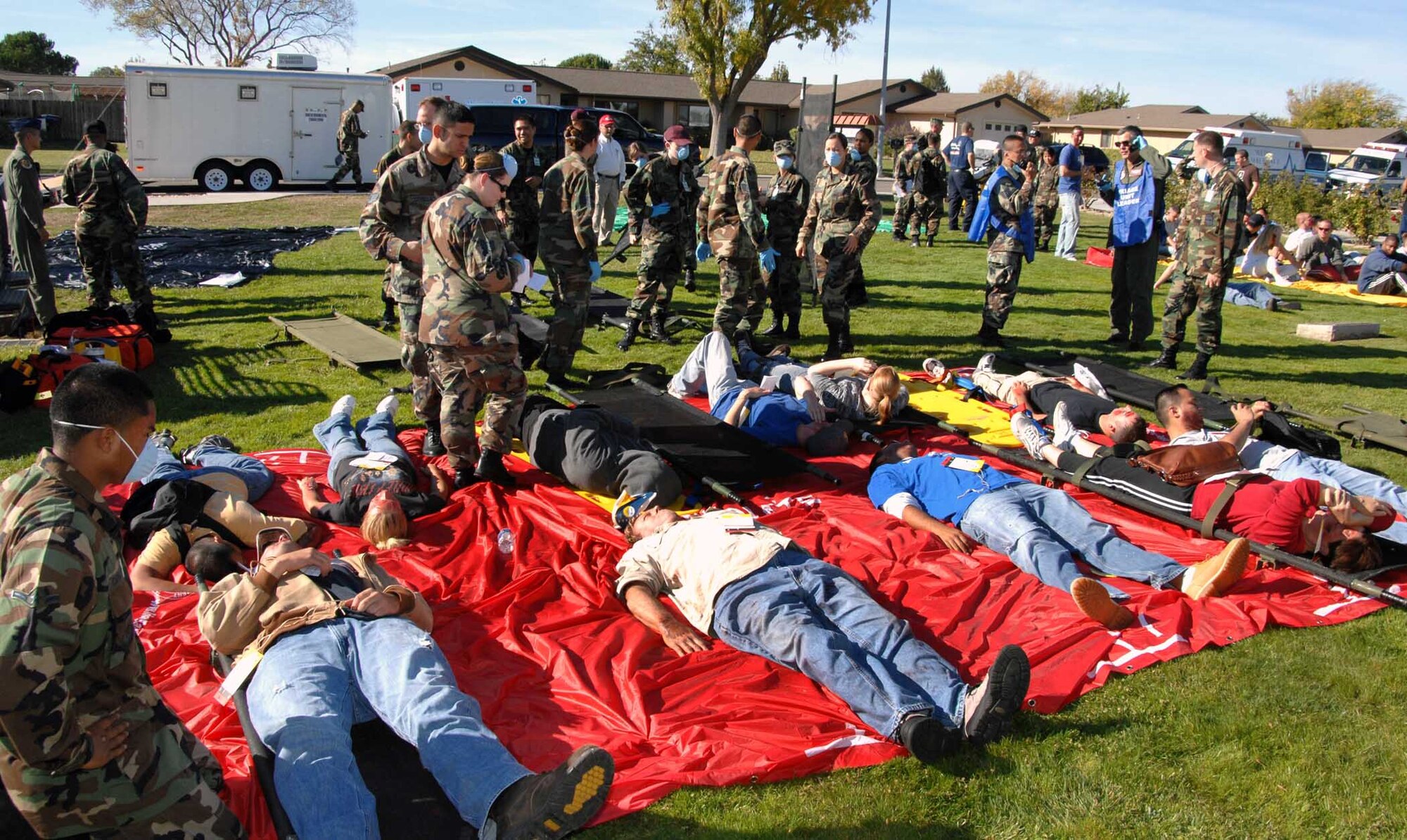 Emergency medical staff treat “patients” at the emergency triage station near the Base Theater during the Home Station Attack Response Exercise Nov. 14. Medical staff simulated transferring “patients” to David Grant USAF Medical Center and various other hospitals. (U.S. Air Force photo)
