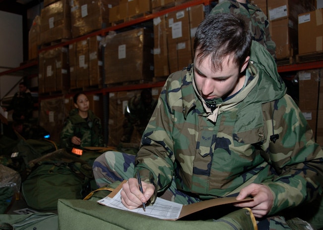 Airman 1st Class Dennis Adams, 437 Aircraft Maintenance Squadron, Auto Flight Instruments Guidance Control Specialist, goes through his mobility checklist to make sure he possesses all of the correct items in his mobility bags, during the base mobility exercise Friday. (U.S. Air Force photo by Airman 1st Class Katie L. Gieratz)