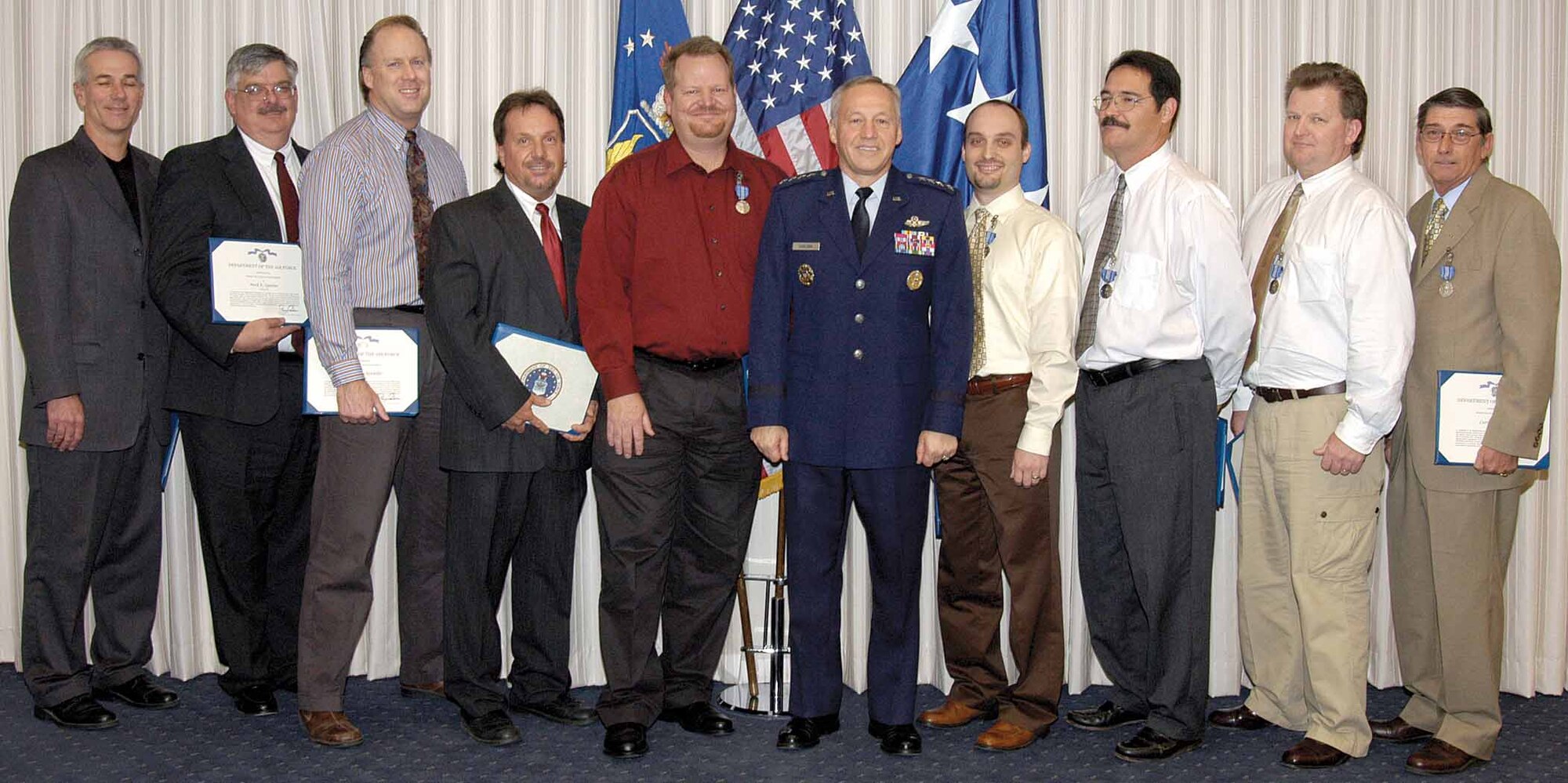 Members of the 555th Aircraft Sustainment Squadron who, in August, assisted in the safe recovery of a crippled B-1 Lancer were awarded the Civilian Achievement medal by Gen. Bruce Carlson in a ceremony at Tinker Nov. 19. Team members posing with General Carlson are, from left; Sam Malone, Mark Quinlan, Mark Druckenmiller, Jimmie Hopkins, Barney Magerus, Kyle Schasteen, Robert Evans, Albert Maeder III and Curtis Smith. (Air Force photo by Margo Wright)