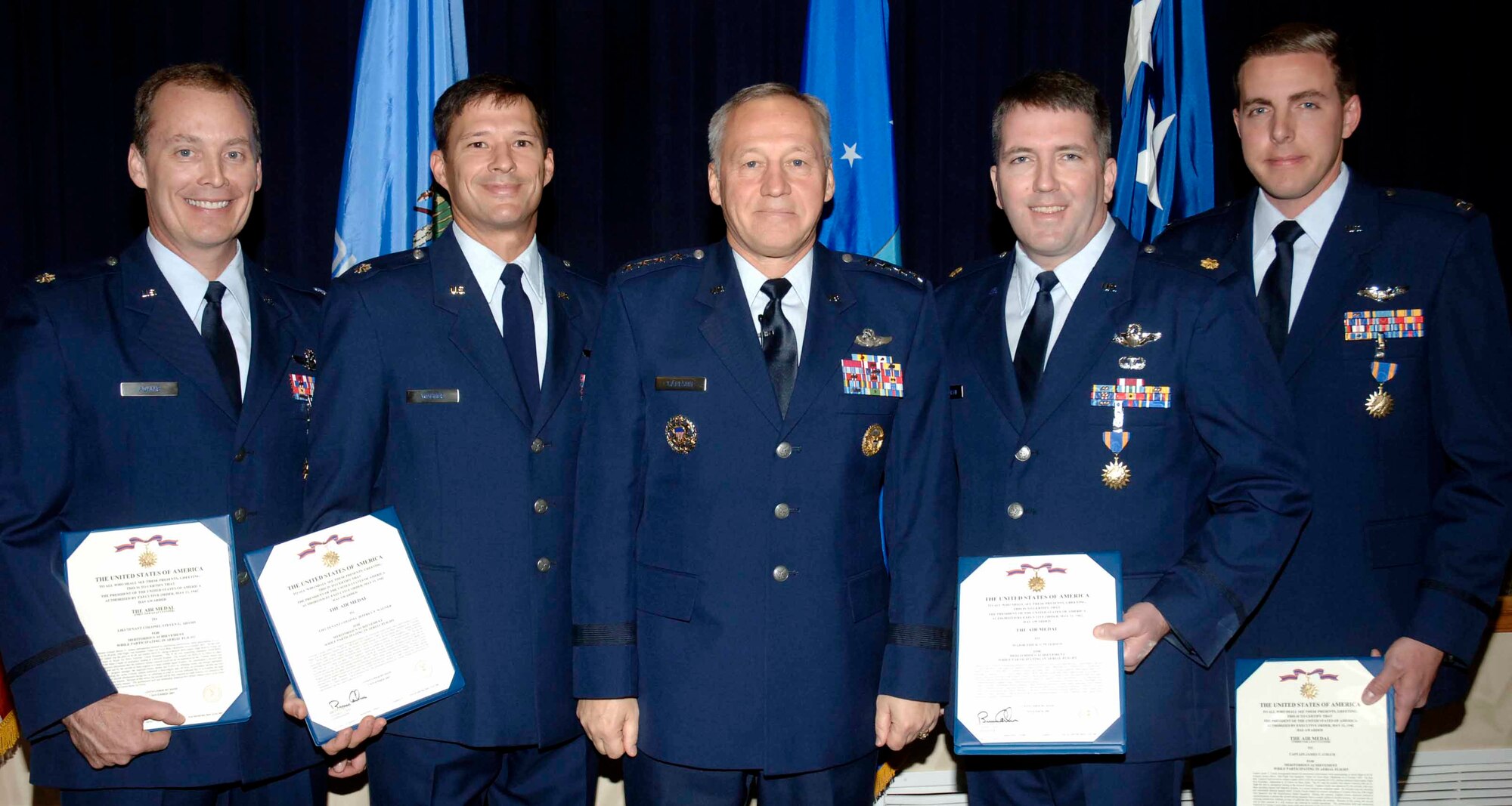 Members of the 10th Flight Test Squadron were awarded Air Medals for their role in flying a B-1 from a combat zone to a safe location for repairs after a combat mission engine fire left the bomber with only three engines.  Gen. Bruce Carlson, Air Force Materiel Command commander, presented the medals in a Nov. 19 ceremony at the Hill Theater.  Awardees pictured with General Carlson are, from left; Lt. Col. Steven Adams, Lt. Col. Jeffrey Wagner, Maj. Erick Peterson and Capt. James Couch.  Major Peterson and Captain Couch were each awarded two medals for their roles in two flights moving the crippled B-1. (Air Force photo by Dave Faytinger) 