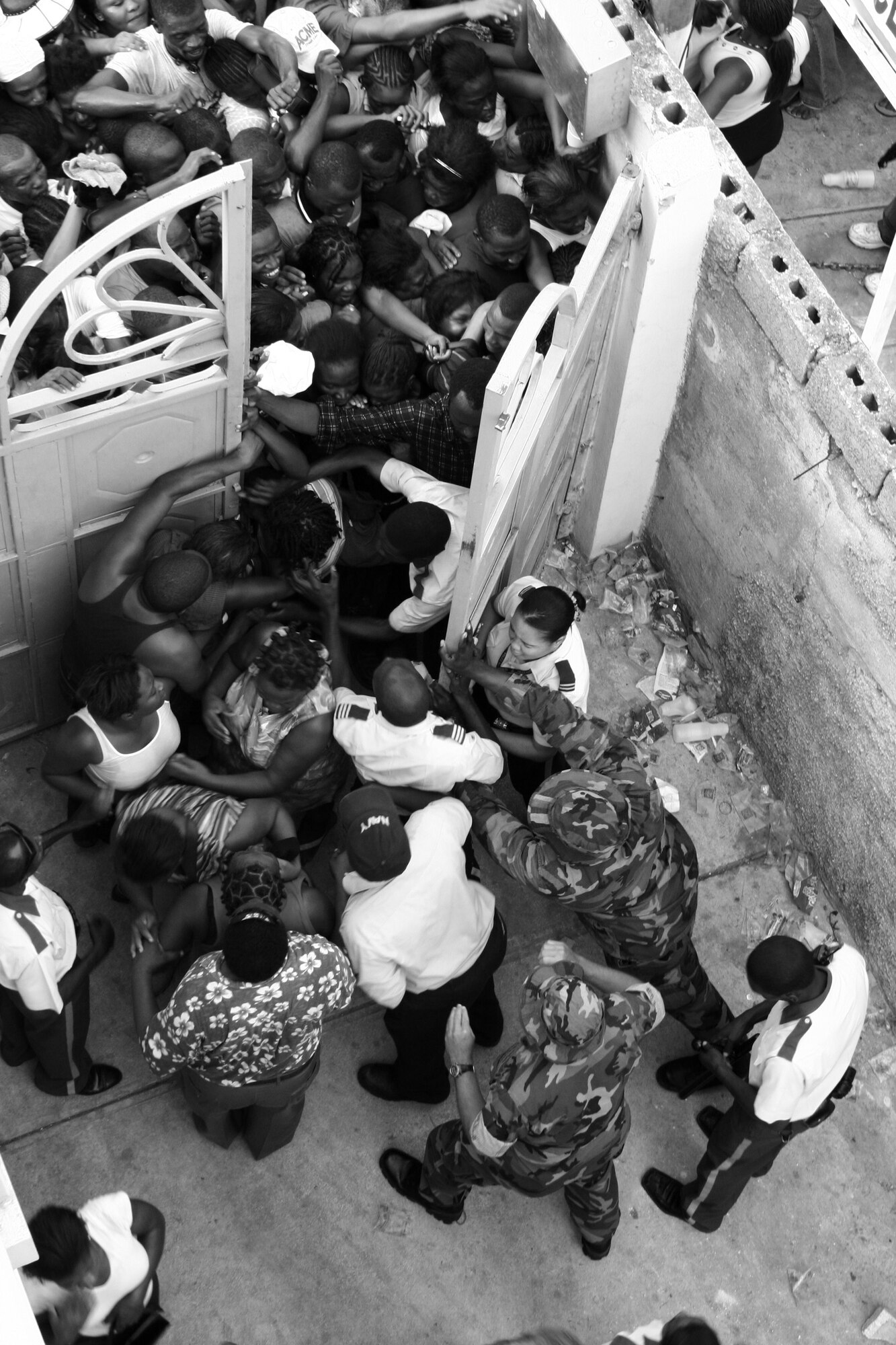 PORT AU PRINCE, Haiti -- Haitians break through the gates at a medical site in September as local police and U.S. medical personnel try to push the doors closed.  (U.S. Air Force/courtesy photo)