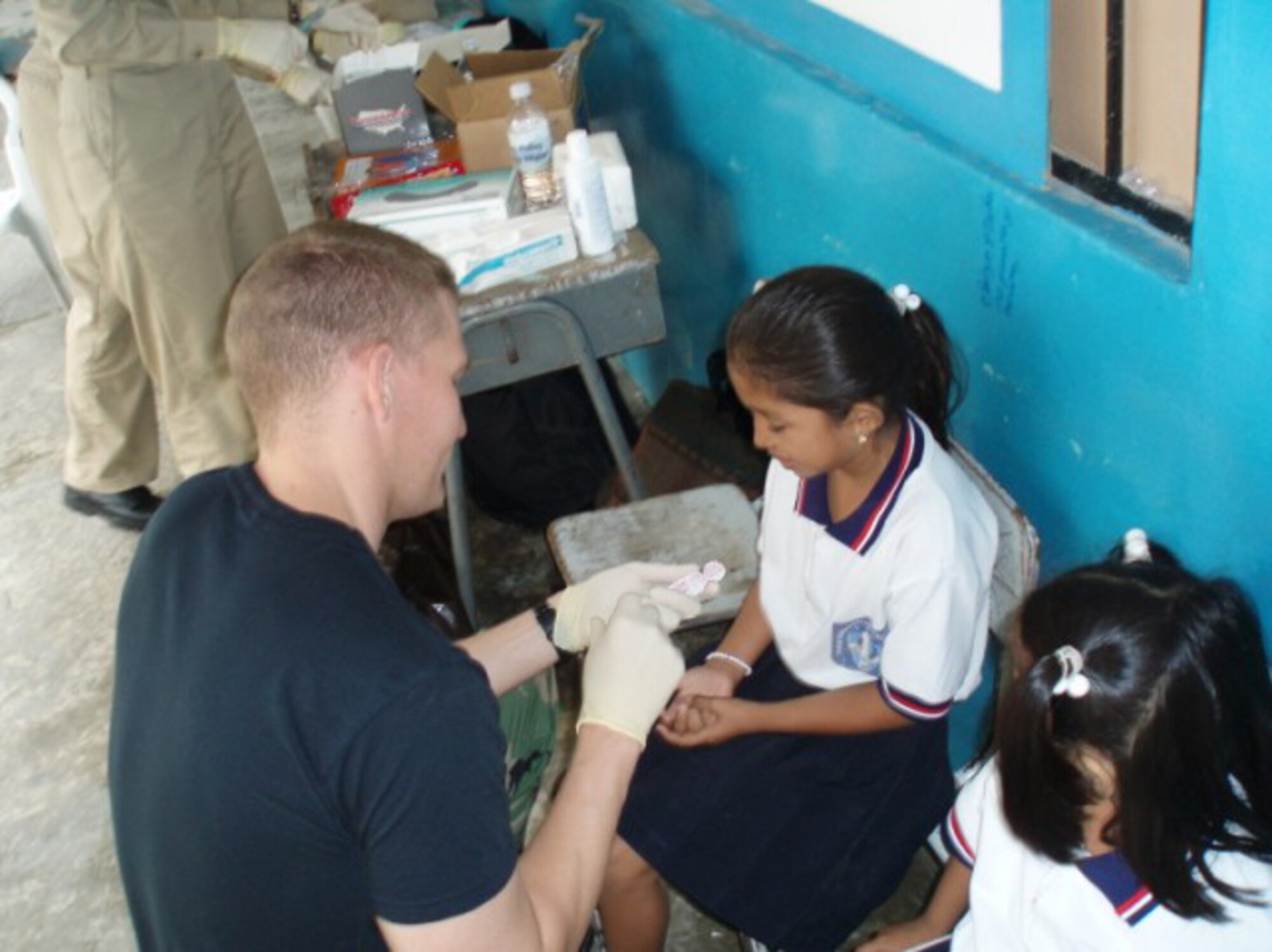 MANTA, Ecuador -- Local children receive fluoride treatments from Tech. Sgt. Jason Conely in August.  While Sergeant Conely's primary job is a radiology technician, he was often called to perform other tasks.  (U.S. Air Force/courtesy photo)