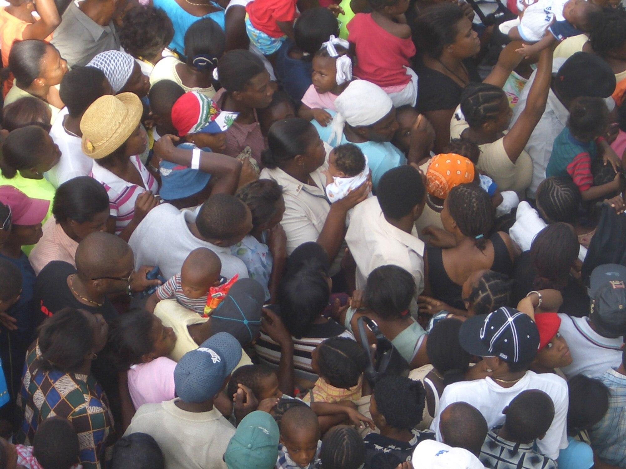 PORT AU PRINCE, Haiti -- Thousands of Haitians push to be seen by U.S. medical workers in August.  Children were held high above the crowd to avoid suffocation.  (U.S. Air Force/courtesy photo)
