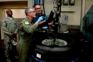 Maj. Gen. James Hawkins, 18th Air Force commander, and Airman 1st Class Stephen McFate, 437th Maintenance Squadron crew chief, tighten bolts on a tire Nov. 14 at the wheel and tire shop.(U.S. Air Force Photo/Senior Airman Nicholas Pilch)