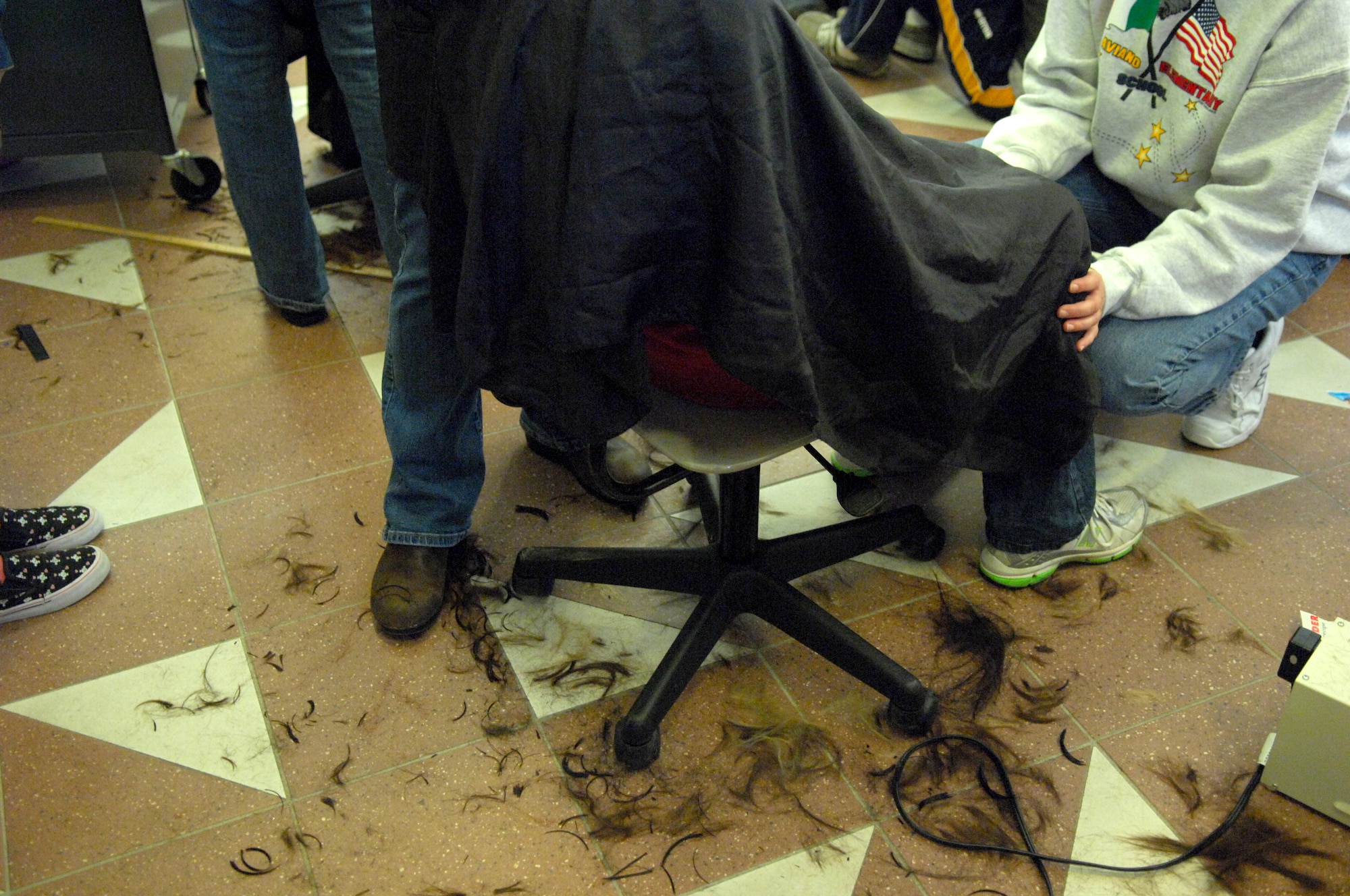AVIANO AIR BASE, Italy-- On the floor of the high school lay the trimmings of young men and women's hair as they donated their long hair to Locks of love. Aviano High School students Dylan Hillestad and Alex Simon organized the hair donation Nov.16, 2007.  Locks of Love is a public non-profit organization that provides hairpieces to financially disadvantaged children under age 18 suffering from long-term medical hair loss from any diagnosis. Locks of Love are unique by using donated hair to create the highest quality hair prosthetics. The prostheses provided by locks of love help to restore self-esteem and confidence, enabling children to face the world and their peers. For more information about Locks of love go to http://www.locksoflove.org   (U.S. Air Force photo/Staff Sgt. Michael R. Holzworth) 