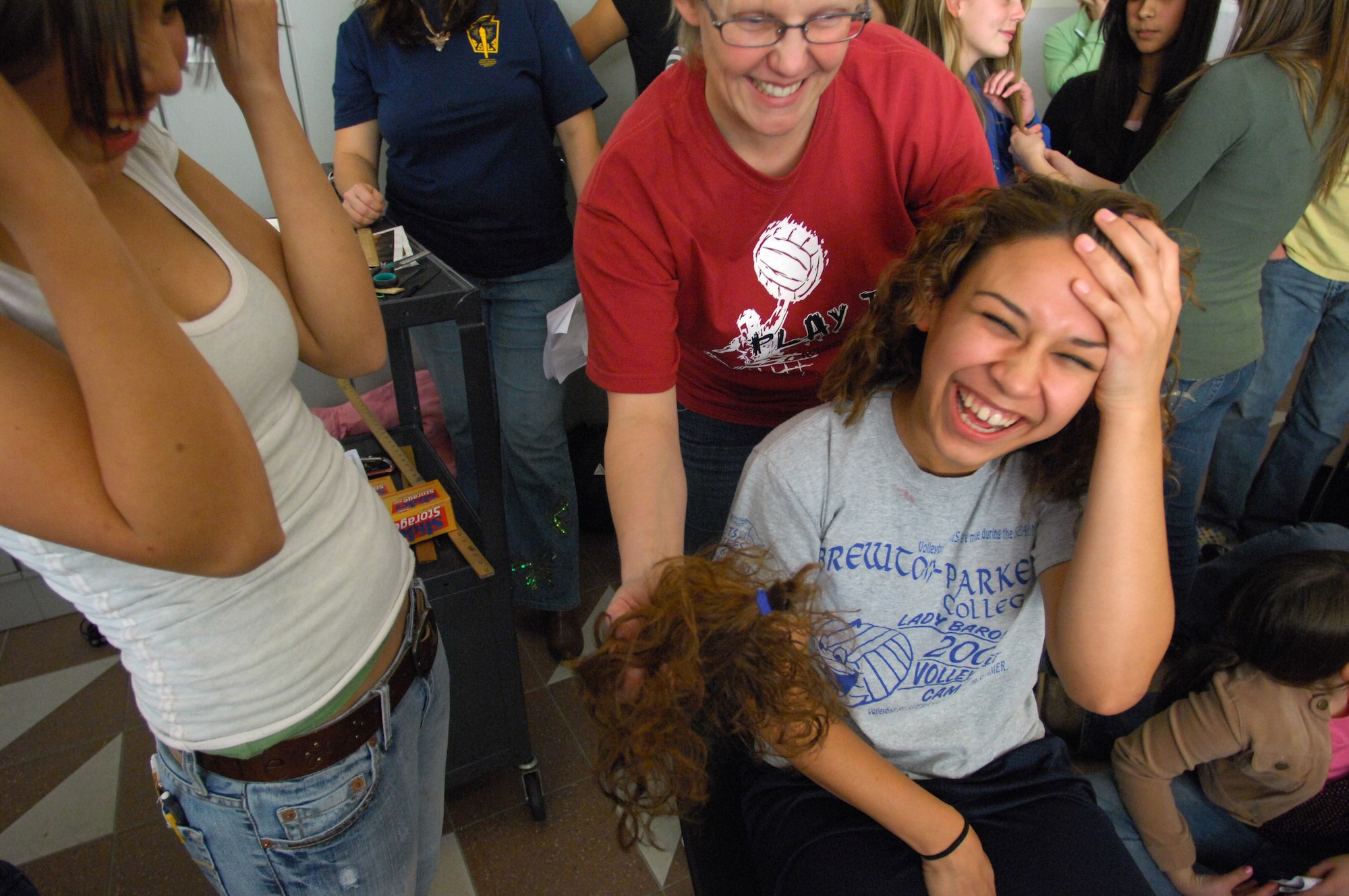 AVIANO AIR BASE, Italy-- Danielle Garcia a senior at Aviano High School laughs as Pam Hillestad shows her how much hair she just donated to Locks of Love. Aviano High School students Dylan Hillestad and Alex Simon organized the hair donation Nov.16, 2007.  Locks of Love is a public non-profit organization that provides hairpieces to financially disadvantaged children under age 18 suffering from long-term medical hair loss from any diagnosis. Locks of Love are unique by using donated hair to create the highest quality hair prosthetics. The prostheses provided by locks of love help to restore self-esteem and confidence, enabling children to face the world and their peers. For more information about Locks of love go to http://www.locksoflove.org   (U.S. Air Force photo/Staff Sgt. Michael R. Holzworth) 
