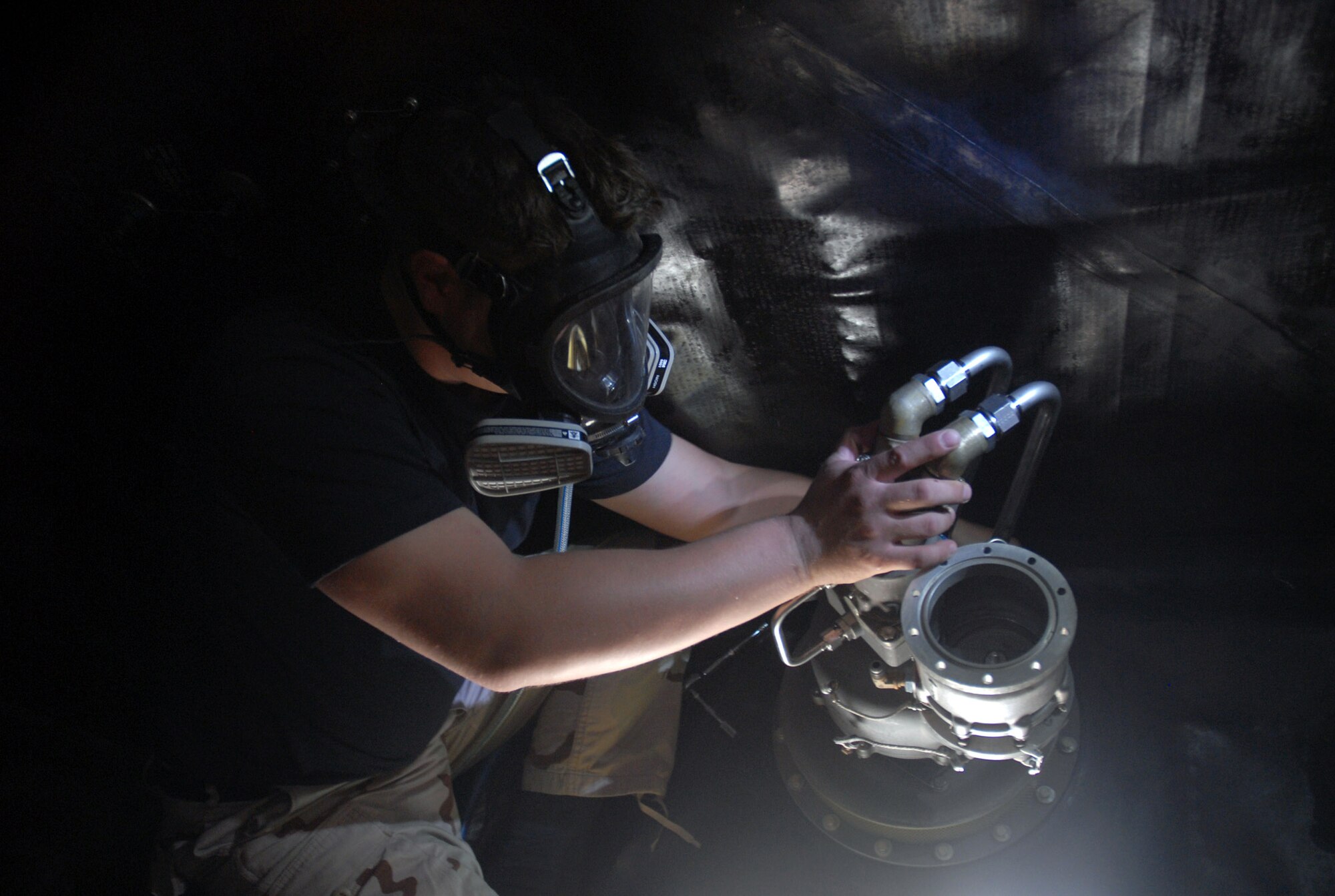 Wearing protective equipment in case of fuel fumes, Airman 1st Class Shaun Carrig installs an air refueling pump in the number three forward body fuel tank of a KC-135 Stratotanker Nov. 17 in Southwest Asia. The new fuel pump with ensure better gas flow for the aircraft. Airman Carrig is a fuel systems journeyman with the 379th Expeditionary Aircraft Maintenance Squadron and is deployed from Grand Forks Air Force Base, N.D.  (U. S. Air Force photo/Staff Sgt. Douglas Olsen) 