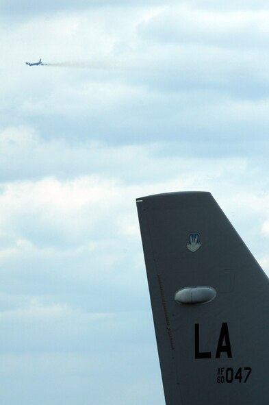 A B-52H Stratofortress is visible over the tail fin of grounded B-52 while it flies over the  Barksdale Air Force Base, La., flightline on Nov. 15 as part of the Buff Smoke Competition between Barksdaleand Minot Air Force Base. (U.S. Air Force photo by Airman 1st Class Joanna M. Kresge)(Released)