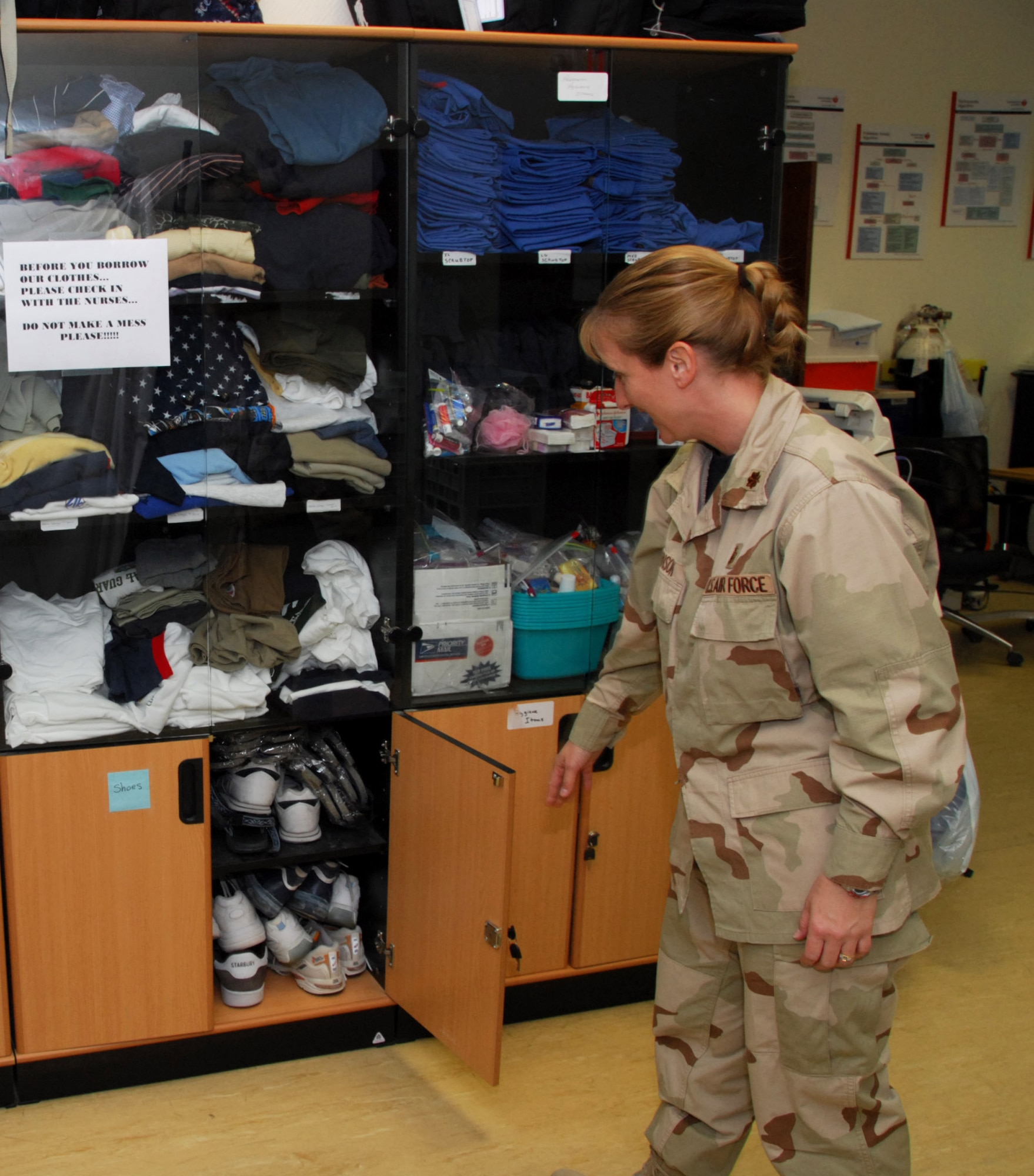 Maj. Nancy Johnson shows off many of the donations made to the Wounded Warrior Wingman program Nov. 12 at the 379th Expeditionary Medical Group in Southwest Asia. Servicemembers are often evacuated without their gear and personal items and arrive at the 379th EMDG with just the clothes on their back. Donations include civilian clothes and toiletries such as shaving kits, toothbrushes, toothpaste, deodorant, soap, shampoo and towels. (U.S. Air Force photo/Staff Sgt. Doug Olsen) 