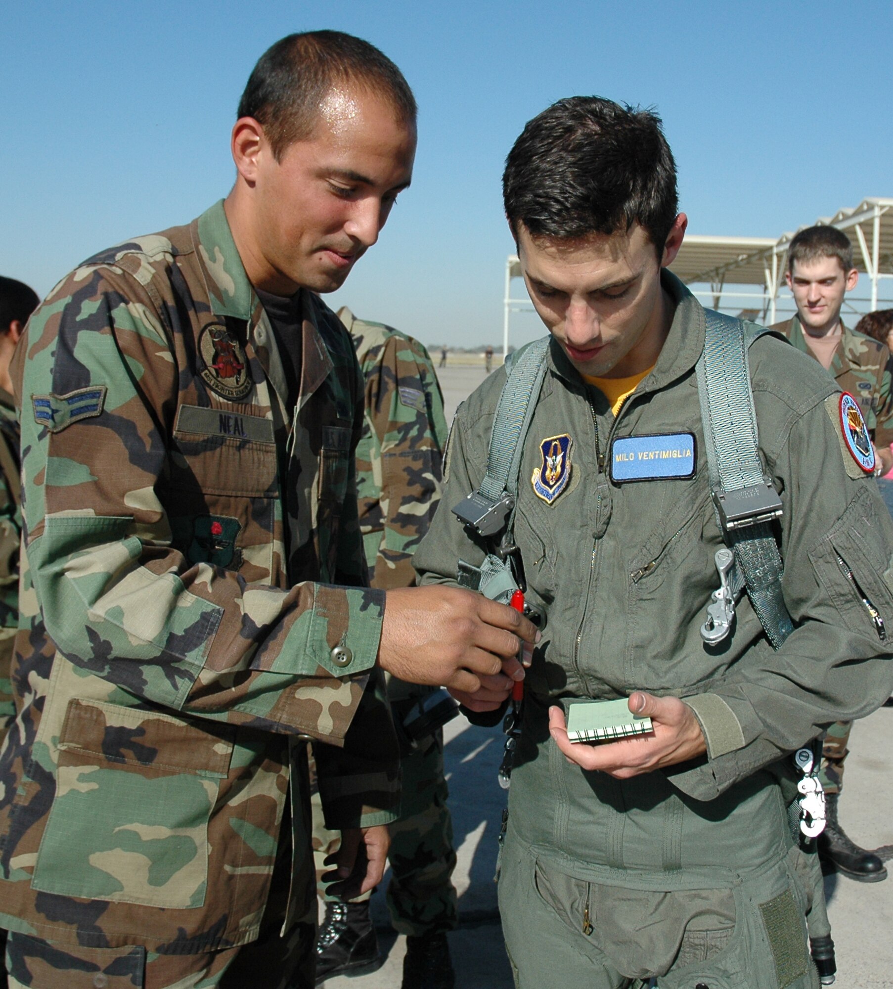 Milo Ventimiglia signs an autograph for Airman 1st Class Matthew Neal, 61st Aircraft Maintenance Unit crew chief, after his F-16 flight Nov. 16. Ventimiglia stars on the TV show Heroes as Peter Petrelli. (U.S. Air Force photo/Tech. Sgt. Susan Stout)