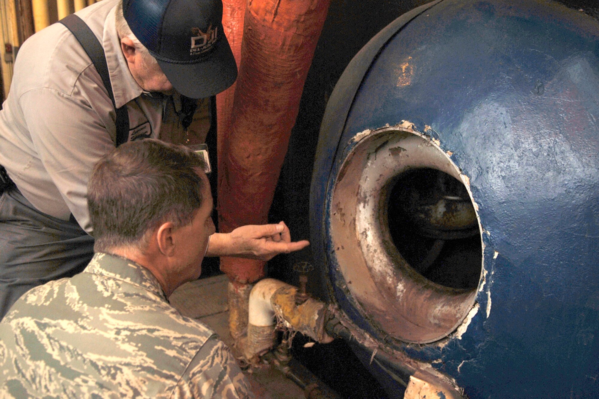 HANSCOM AFB, Mass. -- Larry Morton Jr., Base Steam Plant supervisor, shows Electronic Systems Center Commander Lt. Gen. Ted Bowlds the results of hydro-blasting water tubes that were used to remove scales from one of the steam boilers’ mud drums located in the Base Steam Plant Nov. 16. (U.S. Air Force photo by Jan Abate)