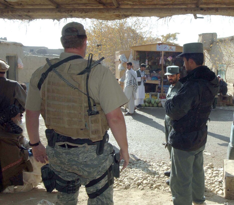 An Air Force Office of Special Investigations agent and Afghan National Police officers speak with villagers during a medical engagement mission here. The ANP and Airmen often work together while providing assistance to local villages, reinforcing the commitment of U.S. forces to build a better Afghanistan. (U.S. Air Force photo by Staff Sgt. Mike Andriacco)