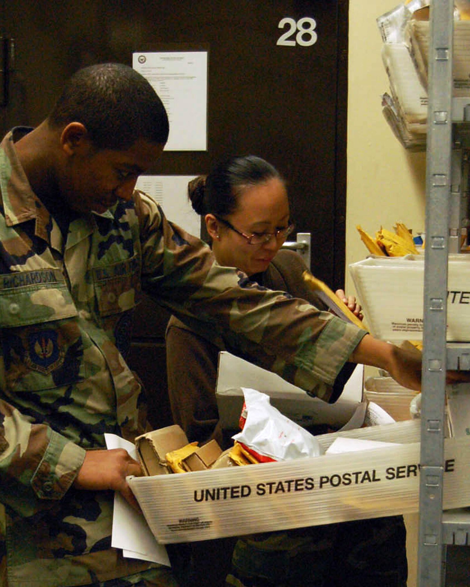 SPANGDALHEM AIR BASE, Germany – Staff Sgt. Roan Deyoung and Airman Jumund Richardson, both from the 52nd Communications Squadron post office, retrieve packages for customers. To help the postal workers from becoming overwhelmed during the holiday season, they are soliciting volunteers to assist them in shelving and distributing mail every day of the week from Dec. 12 - 30 from 9 a.m. to midnight. (U.S. Air Force photo/Staff Sgt. Tammie Moore)
