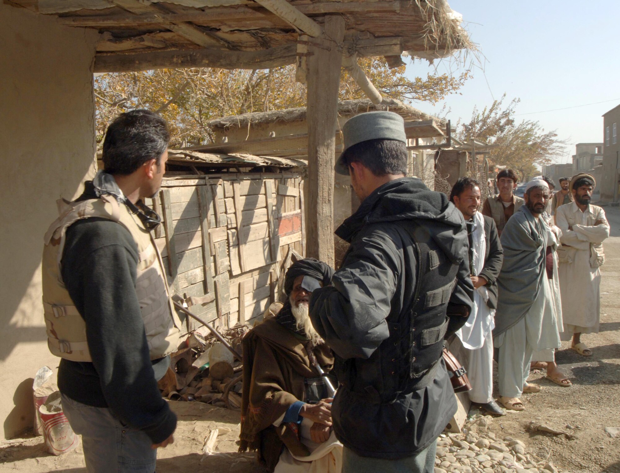 An Air Force Office of Special Investigations agent and an Afghan National Police officer speak with villagers during a medical engagement mission here. The ANP and Airmen often work together while providing assistance to local villages, reinforcing the commitment of U.S. forces to build a better Afghanistan. (U.S. Air Force photo by Staff Sgt. Mike Andriacco)