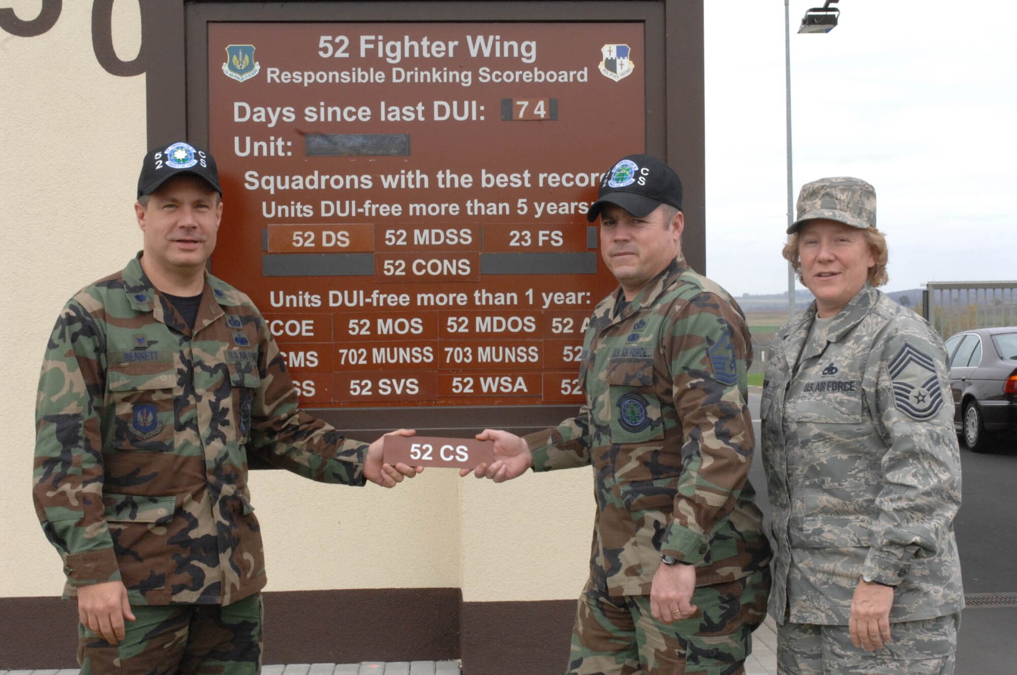 SPANGHDALEM AIR BASE, Germany – Lt. Col. Kevin Bennett, Master Sgt. Joseph Halter and Chief Master Sgt. Venetia Shaw add the 52nd Communications Squadron plaque to the list of squadrons that have gone a year without having a driving while under the influence incident on the 52nd Fighter Wing Responsible Drinking Scoreboard Nov. 4. (U.S. Air Force photo/Airman 1st Class Jennifer Calhoun) 