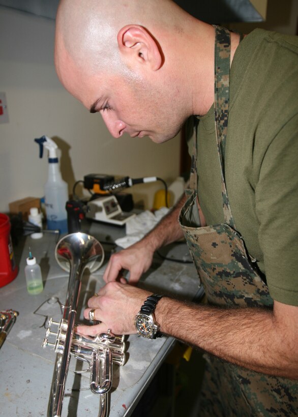 Gunnery Sgt. Andrew Kozain, a native of Pittsburgh, and an instrument repair technician for 3rd Marine Aircraft Wing Band, closely pays attention while working on the trumpet Nov. 17.