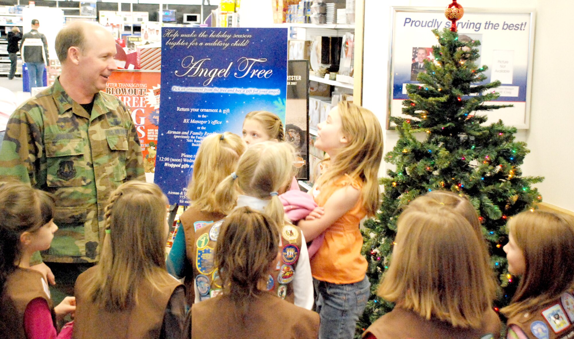 Col. Ron Jenkins, 90th Mission Support Group commander, speaks with children from Brownie Troop 257 and Junior Troop 69 about the Angel Tree Nov. 17 in the BX. After Colonel Jenkins’ introduction, he helped the children place more than 100 ornaments on the tree (Photo by Staff Sgt. Chad Thompson).