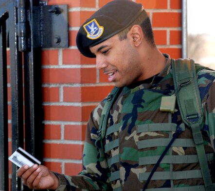 Airman 1st Class William Berrios, 90th Security Forces Squadron, performs installation entry controller duties by checking identification before allowing people on base Nov. 16. Airman Berrios has been at Warren since August (Photo by Airman 1st Class Daryl Knee).