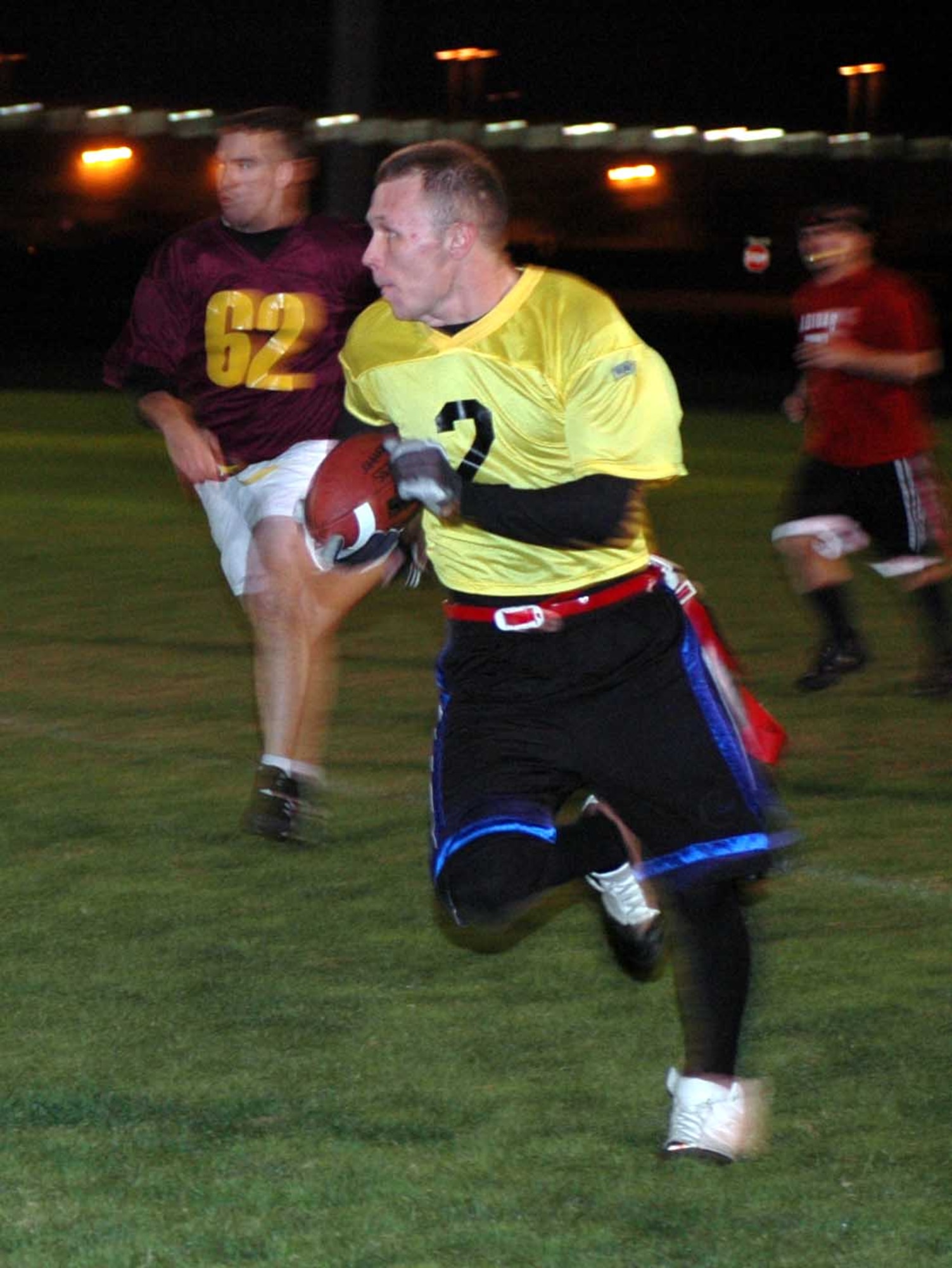 Max Briggs, Travis Red All-Stars’ quarterback, evades defenders on his way to a 25-yard gain during the Intramural Flag Football All-Star Classic Nov. 20.  Briggs threw for 100 yards, two touchdowns and had three interceptions. The Red All-Stars defeated the Gold All-Stars 14-12. (U.S. Air Force photo/Staff Sgt. Candy Knight)