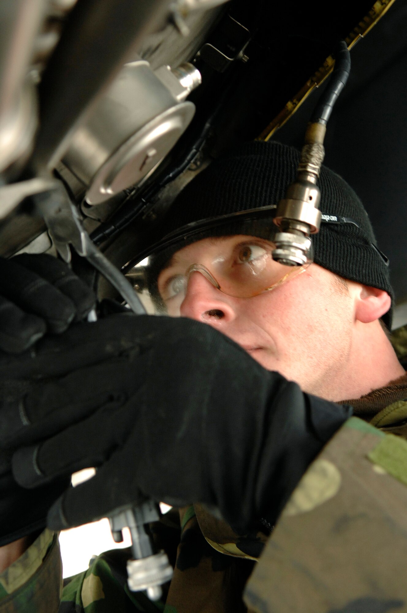 Airman 1st Class Steve Wilson, 28th Aircraft Maintenance Squadron, endures the cold temperatures as he cuts the safety wire on the flame holder inside one of the B-1's engines.  (U.S. Air Force photo by Staff Sgt. Michael B. Keller)