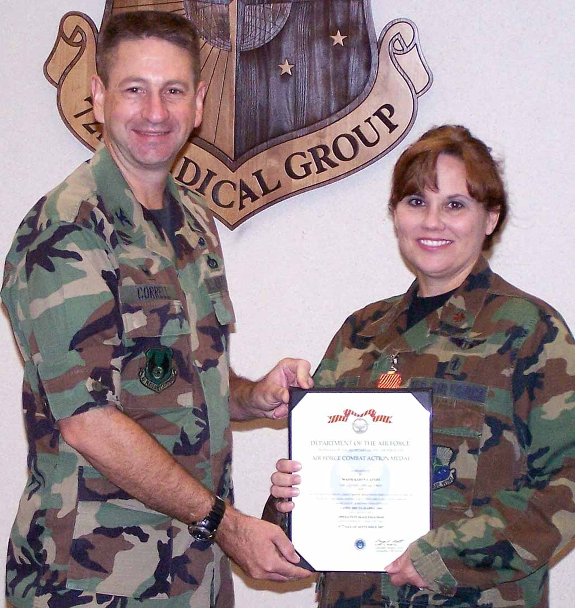 Col. Mark Correll, 72nd Air Base Wing commander, presents Maj. Karyn Ayers, 72nd Aerospace Medicine Squadron flight doctor, with the Air Force Combat Medal Nov. 14. (Air Force photo)
