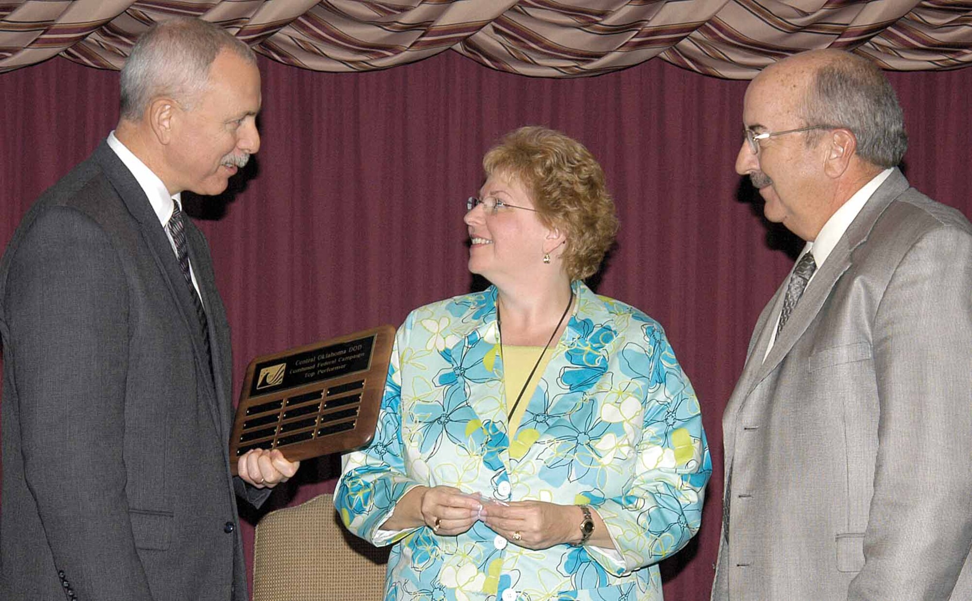 John Over, Oklahoma City Air Logistics Center executive director, congratulates Louise Kregger and John Garbarino, as they accept a Combined Federal Campaign Early Bird award for their Financial Management office.  Ms. Kregger was the CFC monitor and Mr. Garbarino is the deputy director.  Organizations and individuals were recognized Nov. 16 at the Tinker Club celebration for the outstanding support by on and off base donors to this year’s campaign. (Air Force photo by Margo Wright)