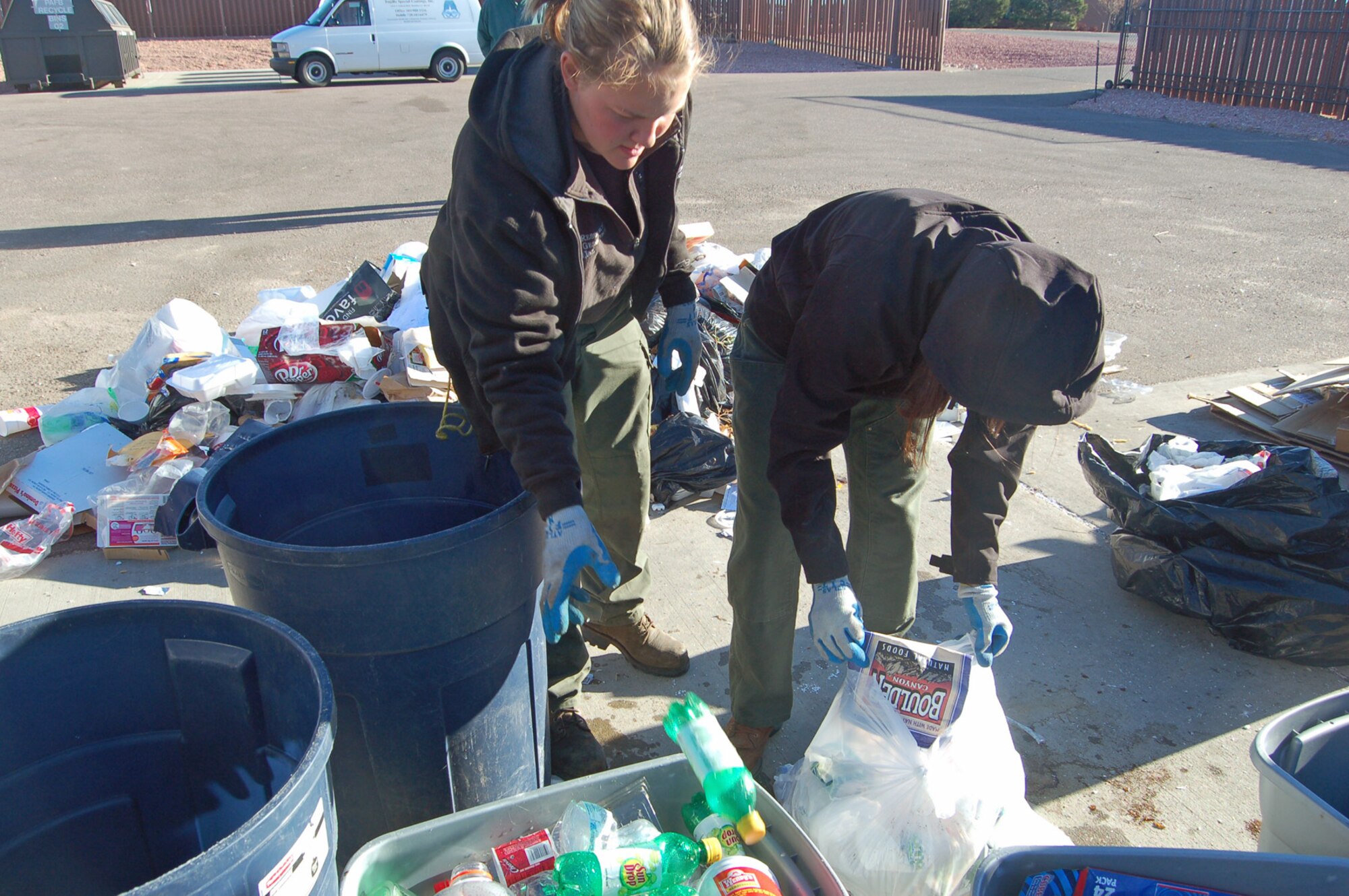 Angela Comer and Danielle Trice, employees with Resource Geoscience, Inc., sort through a week’s worth of trash from Peterson’s dorms. RGI and Booz Allen Hamilton employees teamed up with the 21st Civil Engineer Squadron to sort through the base’s trash in order to discover how many recyclables are ending up in the landfill. (U.S. Air Force photo by Corey Dahl)