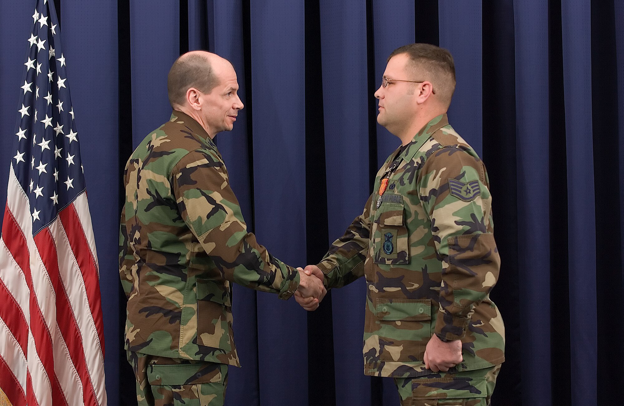 Col. Eric Wydra, 436th Airlift Wing vice commander, shakes hands with Staff Sgt. Michael Grooms, 436th Security Forces Squadron after the presentation of the Air Force Combat Action Medal at The Landings Club Nov. 15. (U.S. Air Force photo/Jason Minto)