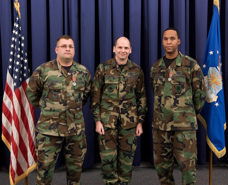 Sergeant Grooms, Colonel Wydra and Staff Sgt. Huey Harris III, 436th Services Squadron, gather on stage after Colonel Wydra presented the sergeants with The AFCAM. (U.S. Air Force photo/Jason Minto)