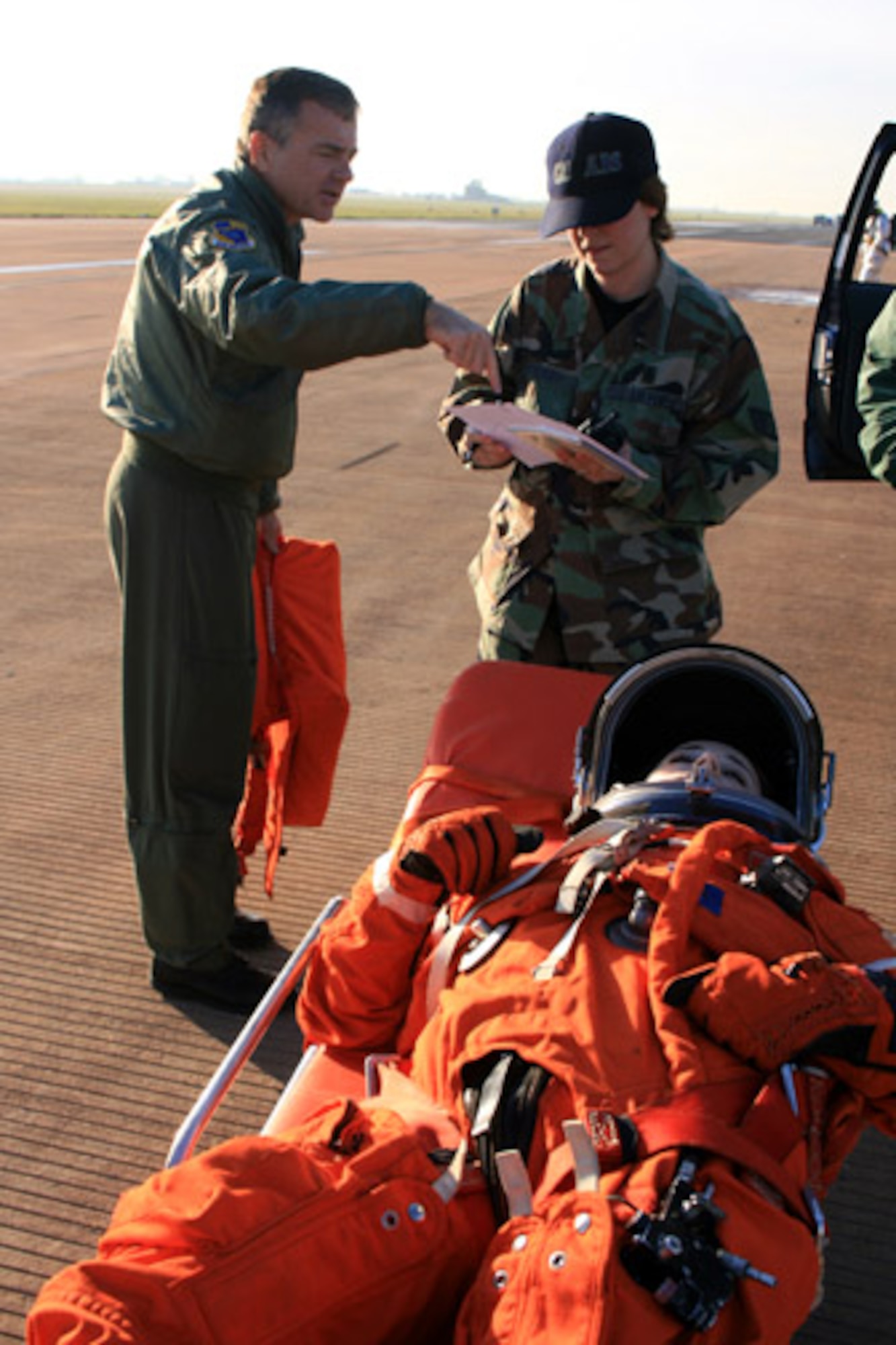 Staff Sgt. Andreana Stockey evalutes a mock astronaut while Lt. Col. (Dr.) Tom Hoffman advises her during a space shuttle recovery exercise Nov. 16. Royal Air Force Fairford, United Kingdom, is one of nine alternate landing sites for the space shuttle. Sergeant Stockey is an independent duty medical technician with the 420th Air Base Group and would be one of the Airmen who would participate the rescue and recovery efforts should the shuttle launch be aborted. Colonel Hoffman is a flight doctor assigned to the 45th Space Wing at Patrick Air Force Base, Fla. The next shuttle launch is scheduled for Dec. 6.  (U.S. Air Force photo/Tech. Sgt. Kristina Barrett)
