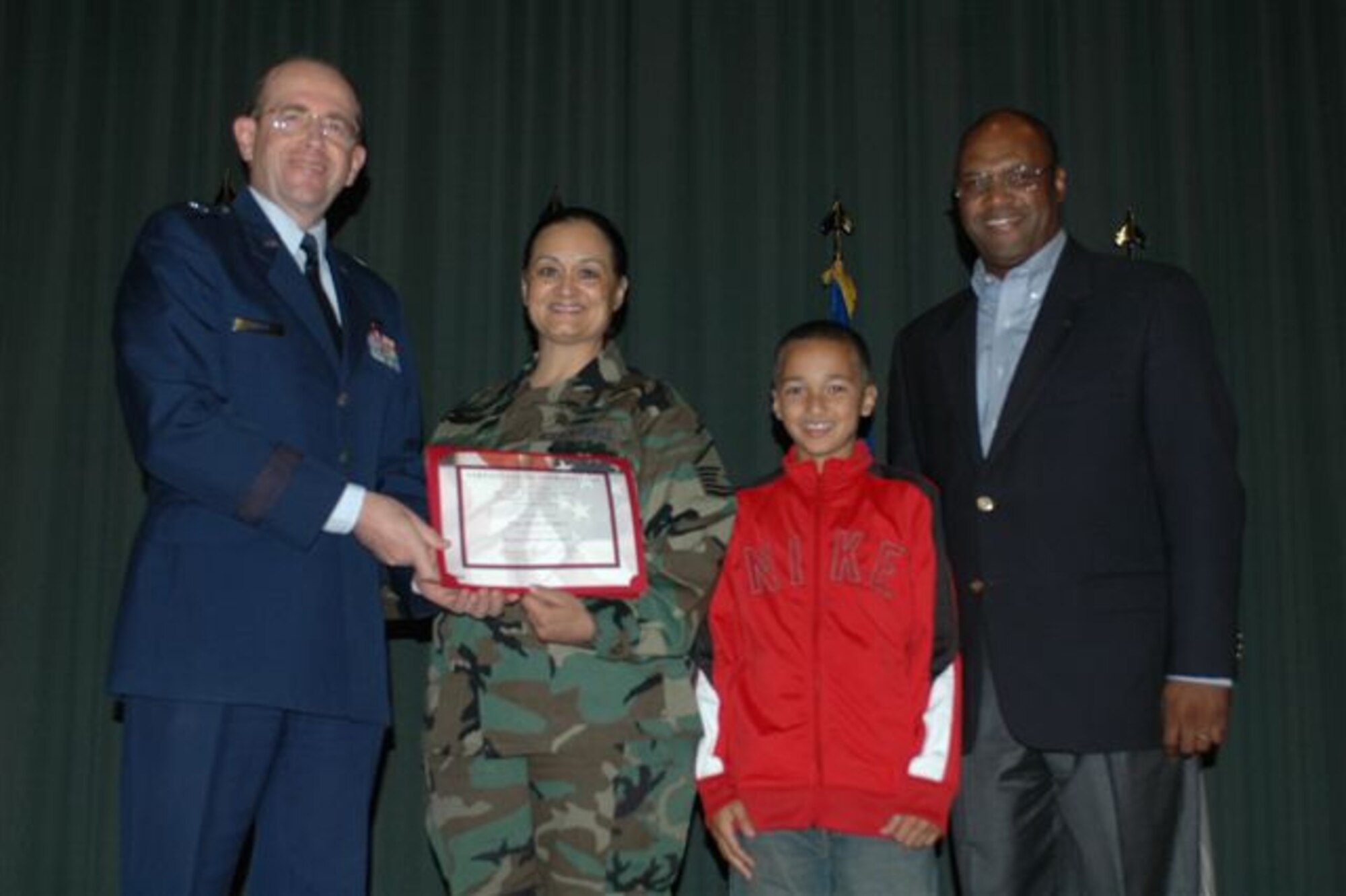 The Silas family accepted the 349th Air Mobility Wing's Military Family of the Year Award at a ceremony held here Nov. 15th. Master Sergeant Pam Silas, son Joseph and husband Ronald accepted the award from Brig. Gen.
Thomas M. Gisler, Jr., commander 349th AMW. (U.S. Air Force photo/Staff Sgt.
Matthew McGovern) 
