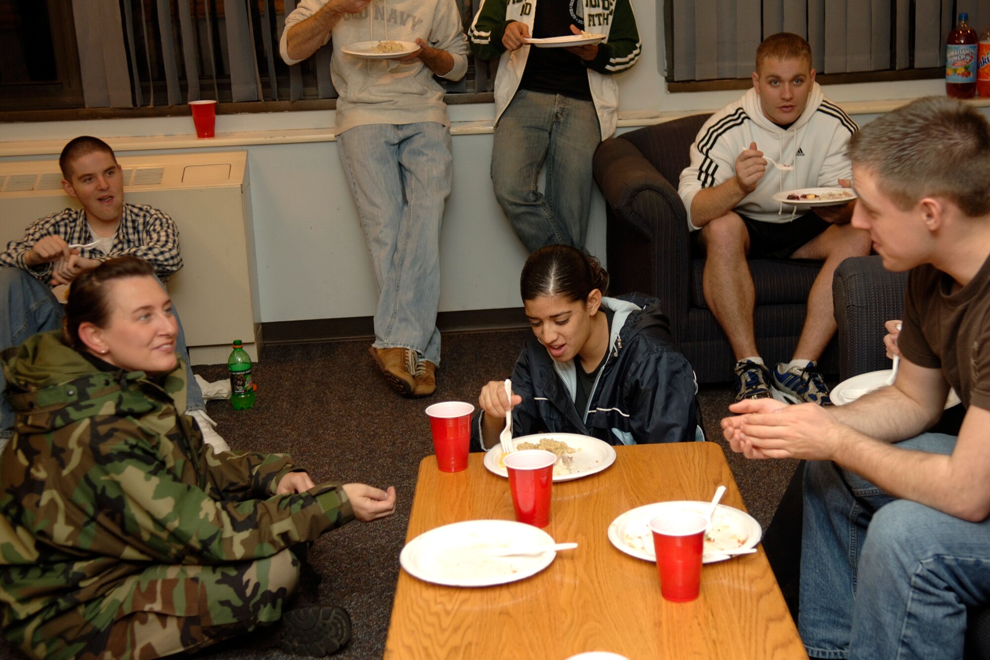 Chief Master Sgt. Karen McCoy, Electronic Systems Center and 66th Air Base Wing command chief, sits and chats with a group of Airmen during the Thanksgiving Dorm Dinner hosted by the Base Chapel Nov. 20.