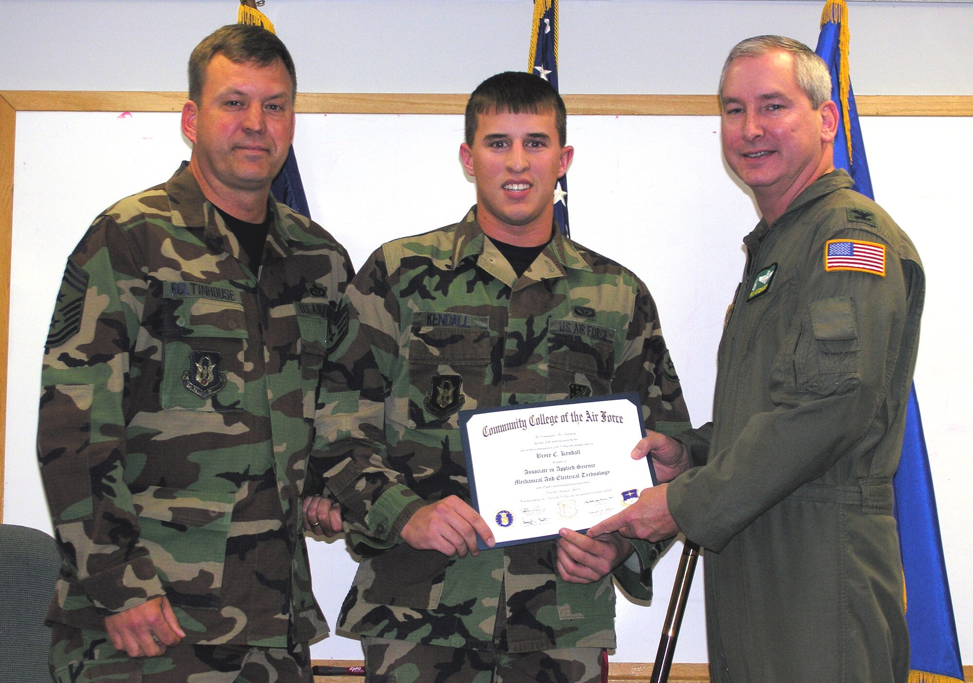 SEYMOUR JOHNSON AIR FORCE BASE, N.C.--Staff Sgt. Bryce Kendall (middle) receives his associate's degree in mechanical and electrical technology from Col. Fritz Linsenmeyer, wing commander (right) and Command Chief Master Sgt. Lester Boltinhouse (left) during the November unit training assembly. Sgt. Kendall is a reservist with the 916th Civil Engineer Squadron. Twelve reservists from the 916th Air Refueling Wing received their higher education degrees from the Community College of the Air Force during an official ceremony in which nearly 35 people attended. Graduations for CCAF students are held twice a year, once in the spring and once in the fall. For more information on obtaining a degree through the CCAF program contact wing training at 722-2232.