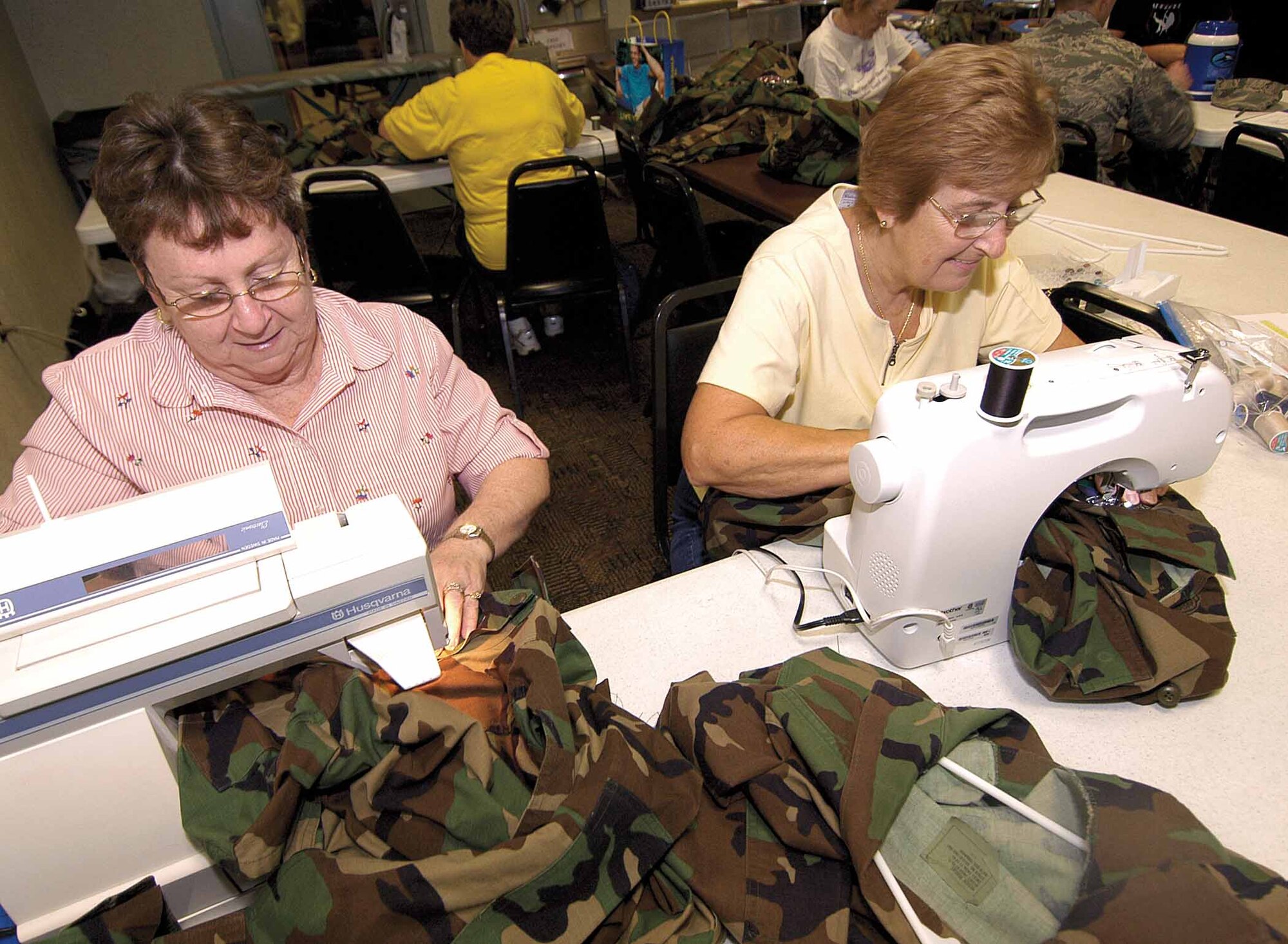 Approximately 13 Airmen took advantage of free food and free patch sewing for the Base Chapel-sponsored Munch and Mend at the Vanwey Recreation Center.  Chaplain (Capt.) Martin Booth signs in an Airman Nov. 13 while volunteers, including Master Sgt. Mavis Durant, 72nd Medical Group Optometry Clinic, work on uniforms. (Air Force photo by Margo Wright)