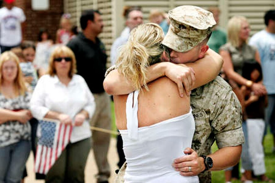 Family and friends give a send-off to their loved ones  assigned to  Fox Battery, 2nd Battalion, 14th Marine Regiment who boarded buses at the Armed Forces Reserve Center Friday  July 13, 2007, on their way to duty in Iraq.  Dr. Heather Cox hugs her (then) fiance, Sgt. Erik Mortenson, from Oklahoma City, before he gets on the bus. (U.S. Air Force Photo/Jim Beckel) 