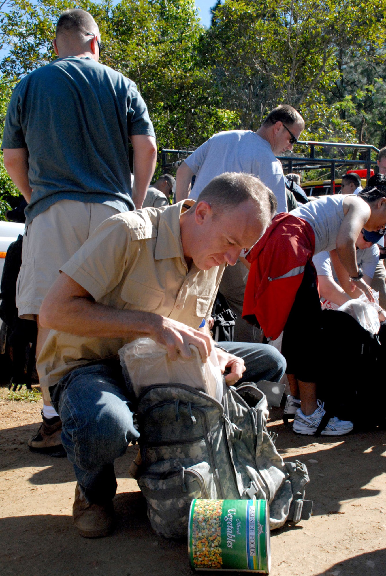 Army Sgt. Eric Gustafson loads donated food into his ruck sack prior to a mountain hike Nov. 17 at La Sampedrana, Honduras. Airman, Soldiers and Sailors from Joint Task Force-Bravo at Soto Cano Air Base, Honduras, hiked five and a half miles up the mountain here to deliver more than 600 pounds of food to local villagers. The hike is the third in a series of five sponsored by the JTF-Bravo Chapel. (U.S. Air Force photo/Tech. Sgt. Sonny Cohrs) 