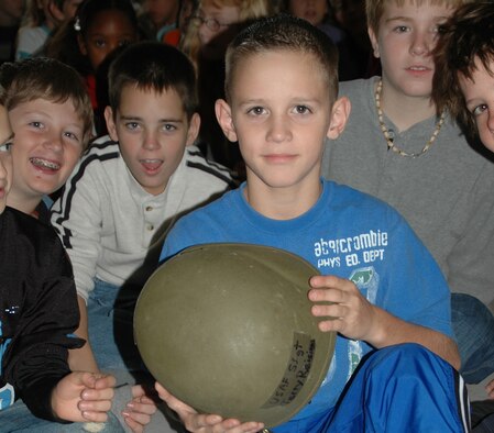 A 5th grader from Alton Darby Elementary School in Hilliard, Ohio, examines a helmet belonging to Staff Sgt. Terry Reisinger, chaplain assistant with the 445th Airlift Wing.  Sergeant Reisinger spoke to the 4th and 5th graders at the school on Veteran's Day, Nov. 12, 2007.  